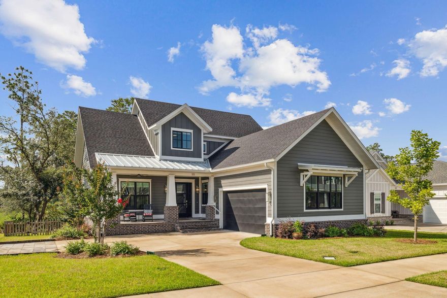 Welcome to this stunning family home in the highly sought-after Deer Moss Creek neighborhood, beautifully nestled against protected green space. Built in 2022 by the esteemed Janssen Construction, this thoughtfully designed residence blends traditional charm with industrial flair.As you approach, three shallow brick steps lead you up to a covered front porch supported by tapered porch posts an inviting space to enjoy peaceful outdoor moments. Step inside and be greeted by an abundance of natural light pouring through large windows, showcasing luxury plank flooring and a cozy brick fireplace, complemented by a gas wall fire that serves as a striking focal point in the living room. The dining area, with dual-aspect windows offering delightful neighborhood views, is ideal for family meals or entertaining guests. The kitchen stands out with its avant-garde style, highlighted by a bold red 36" SMEG gas range that contrasts beautifully with minimalist gray cabinetry. The veined black marble countertops and central island with seating encourage casual conversation while enjoying breakfast. A dedicated laundry room keeps everyday essentials tucked away, and a charming office space is discreetly located behind an antique door for added character.
The first-floor master suite is a true retreat, offering three-directional windows framing tranquil wooded views. The airy cathedral ceiling, adorned with black beams, adds architectural interest. French doors lead into the spacious walk-in closet and the luxurious ensuite bathroom, featuring twin vanities and an oversized glass shower.
A screened porch off the living area invites you to step outside and relax while overlooking the generous, fenced yardperfect for children and pets. There's even ample space to add a pool in the future. The custom elevator provides easy access to the second floor, where an open loft area with a built-in daybed and wet bar offers a great space for relaxation or entertainment. The spacious family room currently serves as a bonus sitting area, ideal for cozy movie nights.
The second floor also includes three tastefully decorated bedrooms, providing ample room for family and guests. With three full baths and two half baths, there's plenty of private space for everyone.
Additional features include a two-car garage, a wide driveway, and access to a range of community amenities, including a clubhouse, swimming pool, basketball court, and playground. Deer Moss Trail is perfect for biking, running, and exploring the scenic surroundings of the babbling creek.
This home is a perfect blend of luxury, comfort, and functionalityschedule a showing today and experience the beauty of Deer Moss Creek!