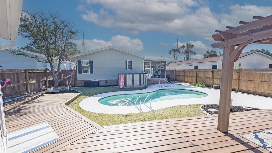SHORT TERM RENTAL allowed, and no HOA make this the perfect Beach location. Laguna Beach another plus, south of Back Beach Road (HWY 98 Done) Move in Ready, new energy saving metal roof installed April 2025, back yard oasis with wooden deck and Gunite inground pool, completely updated interior.  Beach living at its best. Whether it is a primary Home, Second Home or Weekly rental home you are in the middle of all the great places to eat and shop. If you love Entertaining this Back Yard with Pool, wooden Deck with Arbor is your Backyard oasis. Storage Shed 12x10). And leading into the Kitchen is a 14 x 9.9 Screened and covered Porch. Enter into the front door to a Large Family room, Dining Room and Kitchen with stainless appliances, Quartz countertops with subway tile back splash   2 Bedrooms and 2 Full Baths. Beautiful LVP Floors throughout the whole home, 2'' Blinds throughout. New Metal roof just added April 2025. The Home has vinyl siding outside with Brick Underpinning. There is even covered parking and a nice privacy Fenced Back Yard. Make sure to ask for the update list. It is extensive .