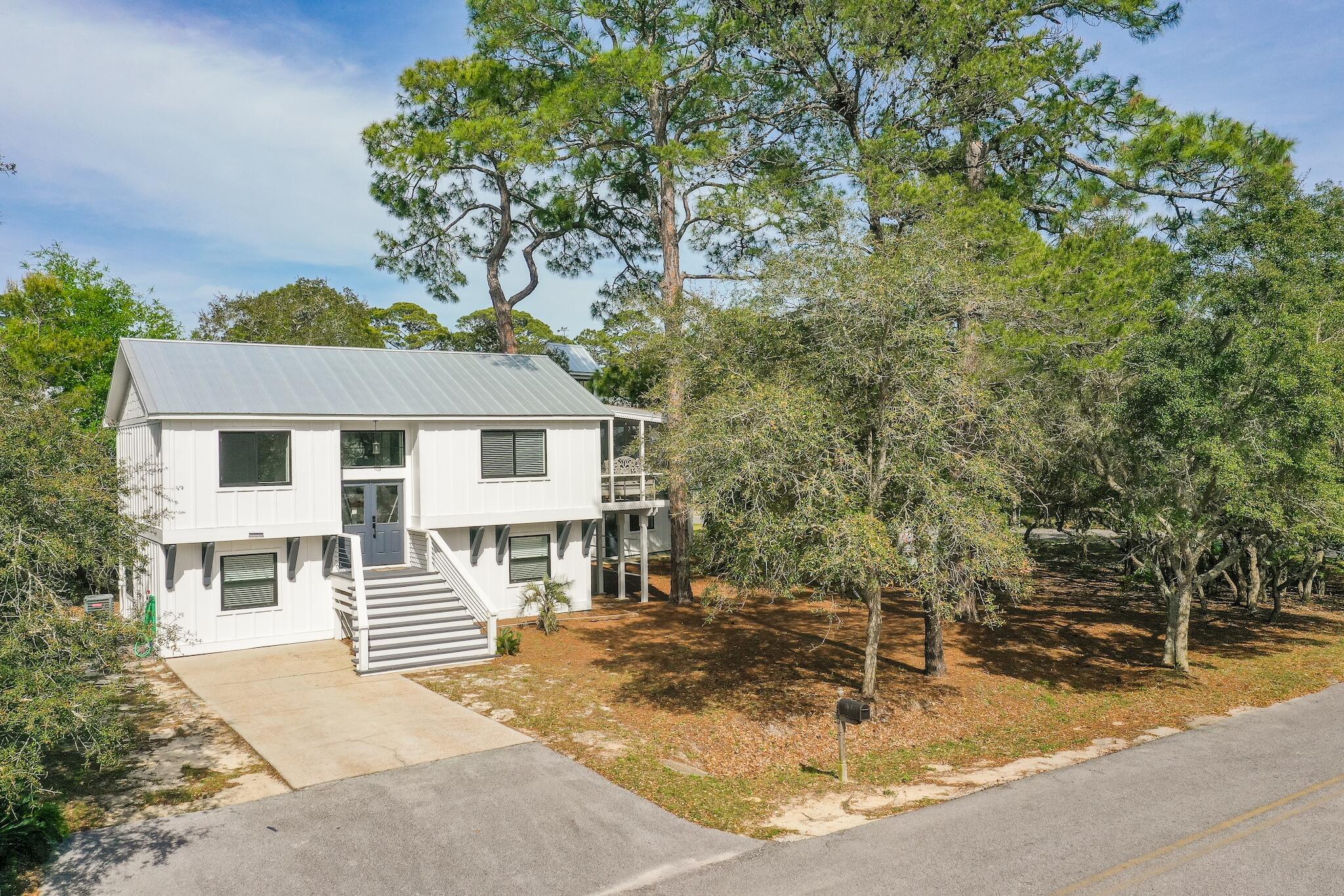 COASTAL 30A CHARM .... Take a short walk to the white sandy beaches of the Emerald Coast from this recently renovated home nestled on an oversize lot with mature oaks and pines. The main house and carriage house consist of 5 bedrooms and 3.5 baths; 3 bedrooms and 2 baths in the main home and 2 bedrooms and 1.5 baths in the carriage house. The main house features an open concept living area with four-panel sliding glass doors opening to a charming screened porch seamlessly joining the inside and outside living. With nearly 1/3 acre, there is plenty of room to add a pool or garage.