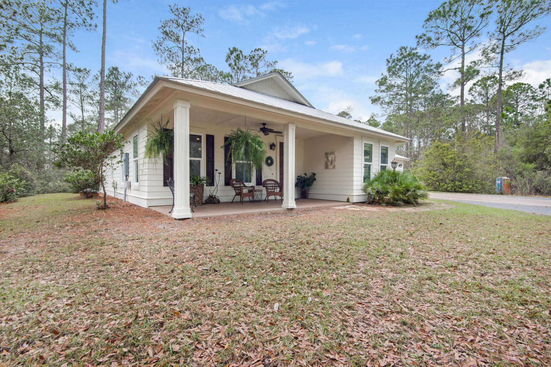 Turnkey beach living is right around the corner with this three-bed, two-bath home on a nearly one-acre lot on a dead-end street in the serene neighborhood of The Woods in Point Washington. Featuring nearly 1,800 square feet of living space ensconced in privacy with plenty of room to add a pool or carriage house, you're just minutes away from the beach and the best dining and entertainment offerings Scenic Highway 30A has to offer. The interior boasts an open floor plan that's light and bright throughout with acacia wood flooring, granite counters, new carpeting replaced in March 2022, upgraded cabinetry, stainless steel appliances and more. A detached two-car garage creates an additional 700 square feet and is connected to the home by a covered walkway. An oversized garage