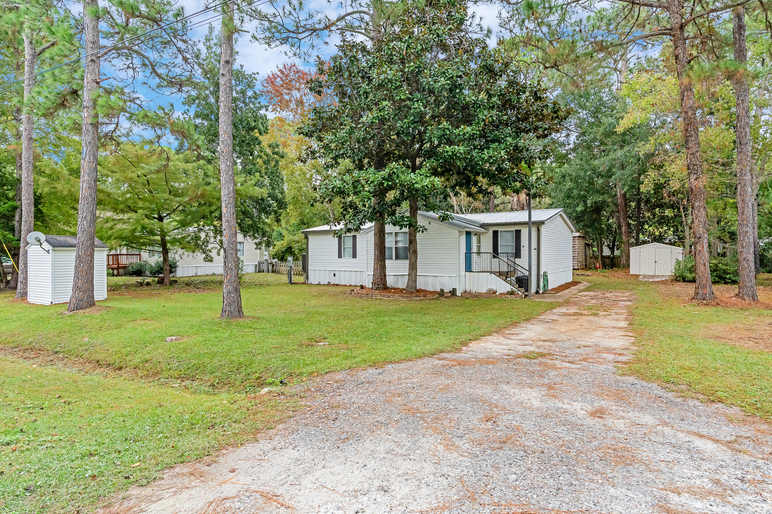 Move-in ready, no HOA! New roof installed October 2021. This property has a 2000 mobile home placed across 2 lots (15 & 16). An 8' x 10' Royal storage building and separate work shed are included on property. Very large deck in back overlooks a brick fire pit. New HVAC system installed 2021. New refrigerator and microwave installed in 2024. Plenty of space to store your boat. Cessna landing park and boat launch is less than 3 miles away. 5 miles to the closest public beach access. Close to the bay and beach, this large, wooded lot is a great site to build a single-family home in South Walton. The lot has all the utilities in place (Chelco electric, Regional Utilities water and sewer, MediaCom). Sold as-is, buyer to verify all information.