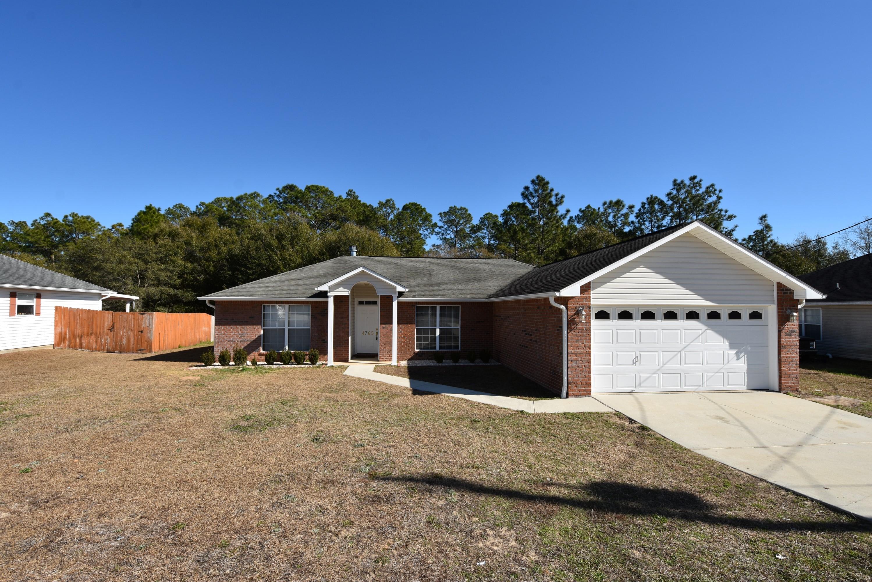 South of I-10 & convenient to the military bases: Duke, Army 7th Special Forces, and Eglin. Plus...the seller will pay most of your closing costs for you and provide a 1-year Home Warranty. NEW HVAC and Dishwasher! Split Bedroom floor plan gives a feeling of spaciousness. Foyer along with the Living Room is accented w/a vaulted ceiling and wood fireplace. Enjoy views of the wooded landscape from the Living Room, Master Bedroom, and one of the extra Bedrooms. The Kitchen has a Breakfast Bar, Pantry, and all of the appliances are included (dishwasher, fridge, and microwave are stainless steel). Master Suite off the Living Room, has a double vanity, garden tub, walk-in closet in the Master Bathroom. The front Bedroom has laminate flooring. Closing costs paid by the seller does not include: