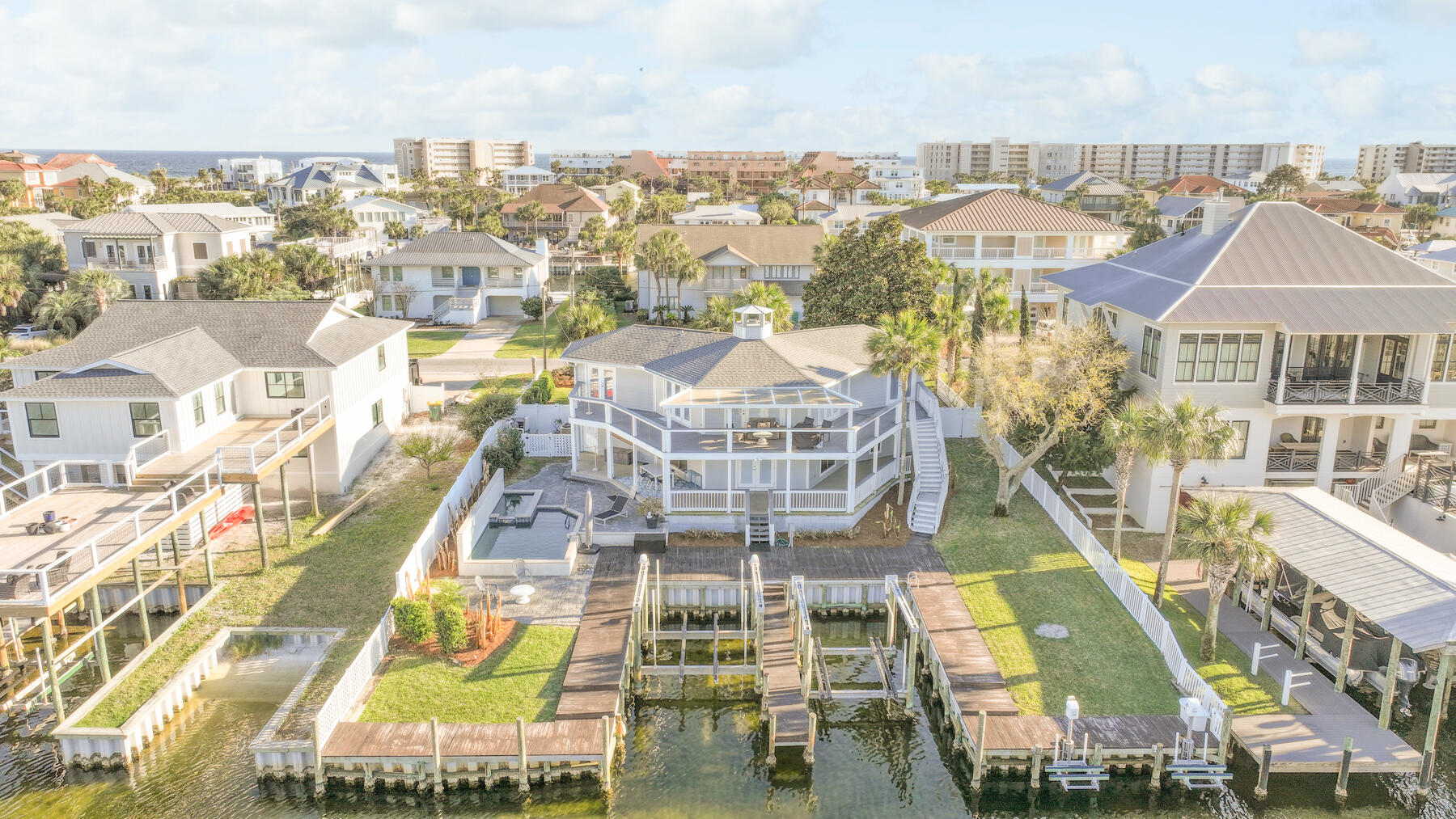 90 ft. of Waterfrontage, 2 Boat Slips, 2 Jet Ski Lifts, Private Pool AND Deeded Beach Access just a short walk or golf cart ride away! The LOCATION can't be beat! Less than 10 Min. to East Pass, The Gulf of Mexico, Crab Island and the Bay by Boat makes for an avid water enthusiasts dream come true! New roof in 2020, and freshly painted in 2023 are just a few of the recent updates. Turnkey & Fully Furnished this home is ready to start making you money or memories immediately, whether it's to be part of your investment portfolio, 2nd vacation home, or full-time residence this beauty is sure to gratify! Your mornings can be spent watching the sunrise & sipping coffee on the expansive wrap around waterfront balconies. Entertain family & friends in the heated pool & spa, grill on the deck, or chill by the fire pit and fish from the dock all in your own backyard. Don't want to take your own boat to the many waterfront bars/restaurants? Call up the water taxi and they will pick you up right from your dock and deliver you to any Harborfront establishment, they even run late to get you home safe! Enjoy all the comforts this unique floorplan offers. The first level boasts 2 Large garages, 1 bedroom with 2 Twins, full bath, laundry room, and a huge extra bonus room that could be used for a game room, extra bedroom/bunkroom, or office. The second floor encompasses 2 spacious private master suites overlooking the water each with their own balcony access, in suite full baths & walk in closets. The 2 bedrooms are separated by a vast kitchen & living space surrounding a cozy fireplace that you must see! Existing survey and additional information is located in the document tab. Walkthrough video available to share upon request. Home is currently a vacation rental with several bookings for 2024. Inquire for more information and to schedule your private showing today! Make this Emerald Coast Beach Home yours today & start living the life you deserve!