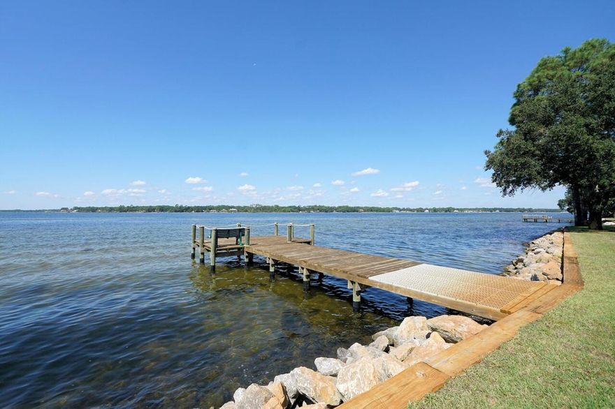 This charming 2-bedroom, 2.5-bathroom townhome nestled in the sought after Bluewater Bay Marina community. Experience a relaxed coastal lifestyle with modern comforts and endless recreational opportunities right at your doorstep!*Spacious layout: with several areas to relax. Once you have parked in your garage you can walk up a few stairs to your first floor. There you can relax by the fireplace or sit on your 14 x6 foot rear deck and enjoy the quiet wooded common area. The second level has an updated kitchen and dining area complete with granite countertops and bright white cabinets and stainless-steel appliances. There is also a screened in porch where you can enjoy the evening breezes. There are two generously sized bedrooms with closet space and each have their own private bathroom. On site, there is a community dock perfect for fishing, paddleboarding, or simply enjoying the waterfront views. You can also take advantage of all of Bluewater Bay offers. You will be in close proximity to swimming pools, tennis and pickleball courts and a top-tier golf course and clubhouse with daily activities. There are numerous pathways ideal for walking or riding bikes, and even a golf cart lane on the main road. There is an excellent seafood restaurant on property that hosts live bands, painting events, paddle board racing and has the most incredible sunset views in the area. THis home is more than just a place to live, it is a LIFESTYLE! 