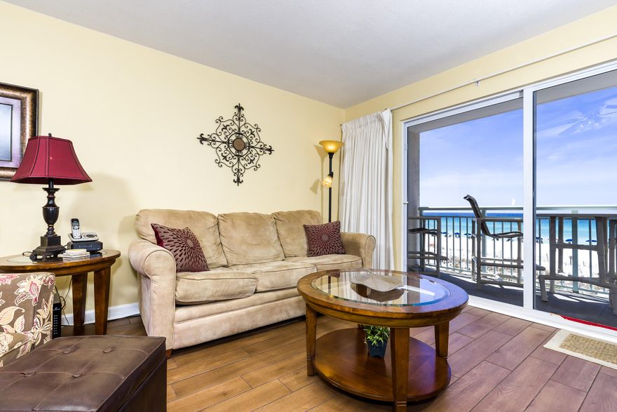 1BR/2BA unit located directly on the amazing beaches of the Gulf of Mexico. The cheerful master bedroom has a comfortable king size bed, and access to a full bathroom that doubles as a convenient powder room. The open living area has a double panel sliding glass door that leads out to the private balcony where you have front and center views of the glistening gulf. A table with four chairs allows you to dine el fresco if you so desire or enjoy favorite drinks and appetizers while taking in the views. The furnishings are absolutely charming with warm brown toned colors that include two armchairs and a beige colored couch. Decorative accents and prints adorn the walls providing a refined rich feel. The kitchen features all appliances and a breakfast bar with two bar stools for the ea