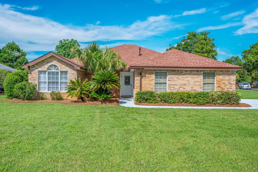 Enjoy the Sunsets over the Bay from this spacious Brick home, on an oversized corner lot and across from the Community Dock!  Fireplace, vaulted ceiling, split bedroom plan, natural gas stove and outdoor grill hookup on the screen back porch.  Newly painted interior, new kitchen countertop, roof replaced in '24 and carpet in '25.  Community Amenities include tennis courts, pool and picnic area - just a short distance from this lovely home. Silver Sands Outlet Mall, restaurants, grocery and Beach access are only a few blocks away.  Easy access to Hwy 98 with a traffic signal at the subdivision entrance.  This home is priced to sell and is ready for your own customization and renovations.    Waterfront conveniences without the Waterfront Price!  Come view this home before its gone!