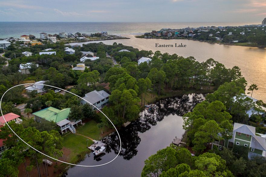 PRICED TO SELL!! This charming home is situated on one of 30a's rare & beautiful coastal dune lakes. Enjoy boating, kayaking and yolo boarding on Eastern Lake from your backyard to the beach and turquoise waters of the Gulf. The home is a reverse floorplan and the second floor features a great room with living, kitchen and dining area that open onto a beautiful deck and/or a screened-in porch, both providing panoramic lake views. The second floor also includes 3 bedrooms and 2 full baths. The first floor includes another living area with full kitchen, two additional bedrooms, a full bathroom and an extra large laundry room. All the bathrooms have been updated to include Carrera Marble, wood floors and artisan cabinets. Home has it's own boat dock with lift and is located south of 30A, just a few blocks the beach. Home could easily be converted into a 4 bedroom home with a 1 bedroom apartment.  Enjoy life on one of the extraordinary coastal dune lakes while being steps or a short paddle away from our areas stunning beach.  Note*A 15' Boston Whaler, home furnishings, kayak, and two YOLO boards are available for purchase outside of a contract.