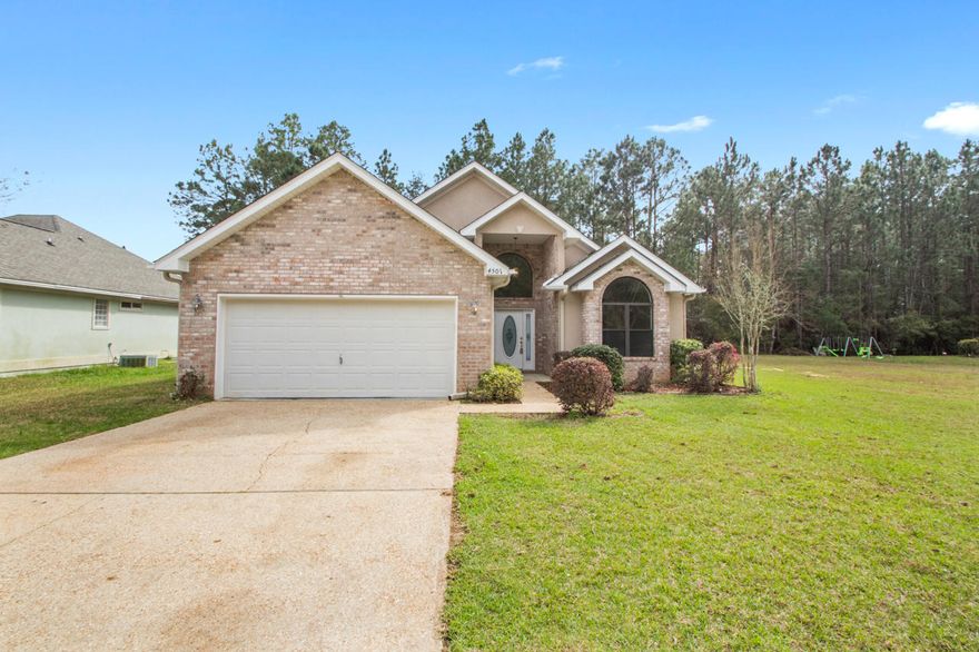 Well thought out floor plan, open living and dining space with vaulted ceilings and a very large kitchen, and new granite counter tops. Off the living room is also an exit to the porch and backyard space - perfect for entertaining! The living room has built-in shelving, fireplace and new carpet! The kitchen features 42 in upper cabinetry, a large island and an abundance of lower cabinets, perfect for those who enjoy cooking. Off the kitchen is a dining room that could be used as an office. This split floor plan home features the master bedroom in the rear with a private exit to the screened-in porch. An ample sized en suite bath with a soaking tub, separate walk-in shower and walk-in closet space. Towards the middle of the home off the living room are two additional bedrooms and a large hall bathroom with tub/shower surround. In the front of the home off the foyer is the entrance to the 2 car garage and laundry room. The foyer and laundry room is tiled making for a welcoming entryway.