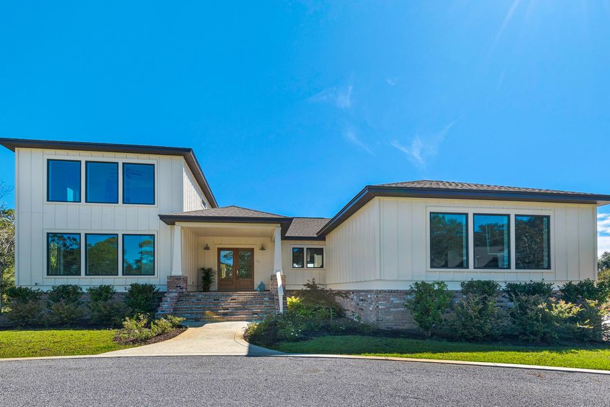 This extraordinary, two story new construction home resides on a large corner lot offering 43 feet of waterfront on Chinquapin Bayou, located in Soundside East in Gulf Breeze. It features a spacious open floor plan perfect for entertaining, cascading sliding doors open up to a covered lanai that your guests will surely enjoy. Upon entry, you'll note plentiful natural light provided by a multitude of windows looking onto the canal, high ceilings, a welcoming great room with beautiful hardwood flooring throughout, with a gas fireplace. The open kitchen has beautiful Quartz counter tops, full-size separate refrigerator and freezer, gas hood range stove nestled into the island which overlooks the dining area & dry bar fully equipped with a wine fridge and separate beverage fridge. There are 2