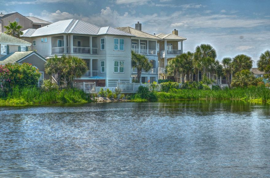 This stunning brand new coastal lake front home offers views of Lake Caroline and glimpses of the Gulf & Destin's East Pass. This magnificent home features dovetail rafters, Hardiboard siding, covered porches and blends seamlessly, timeless coastal architectural details with today's rigorous construction standards. This home is a Fortified Gold Construction Inspection Designated Home, which means a minimum of 20% savings on homeowner's insurance annually. This Builder is known for using the highest construction standards; including the use of impact resistant windows and doors that are designed to withstand 150mph wind loads. Additionally, the builder uses all stainless steel screws, nails, flashing & straps to withstand the harshest environmental conditions. The attention to detail continues inside with vaulted wood ceilings, reclaimed architectural beams and timeless wood floors. The open kitchen offers custom wood cabinets, granite counters and stainless appliances and is perfect for entertaining. There are five master suites plus a custom bunkroom that make this home the ideal family retreat or investment property. The owner's suite, boasts water views and is the perfect retreat after a day spent at the beach. The large ensuite has both his and her vanities, an oversized walk-in shower and a separate soaking tub.  Enjoy the gulf breezes from anyone of the four large covered porches that offer spectacular views Lake Caroline. Located inside the gates of the Island Neighborhood of Destin Pointe, this home is near one of the several private beach walkovers, so there are no busy streets to cross to get to the beach. The main floor covered balcony is the ideal outdoor entertaining venue.