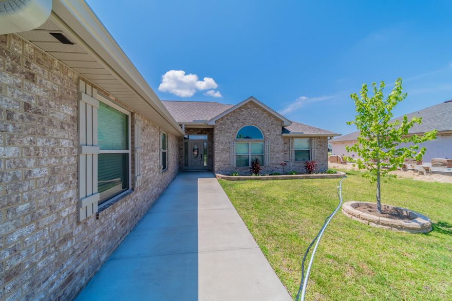 This all brick home features a split floor plan with 3 bedrooms and 2 baths.  The master bath boasts his & hers double shower and two walk in closets. Real wood cabinets in the kitchen, solid surface countertops, and stainless steel appliances.  Electric fire place and crown molding in the living room. Beautifully landscaped lawn, enclosed screen patio, outside shower, and sprinkler system.