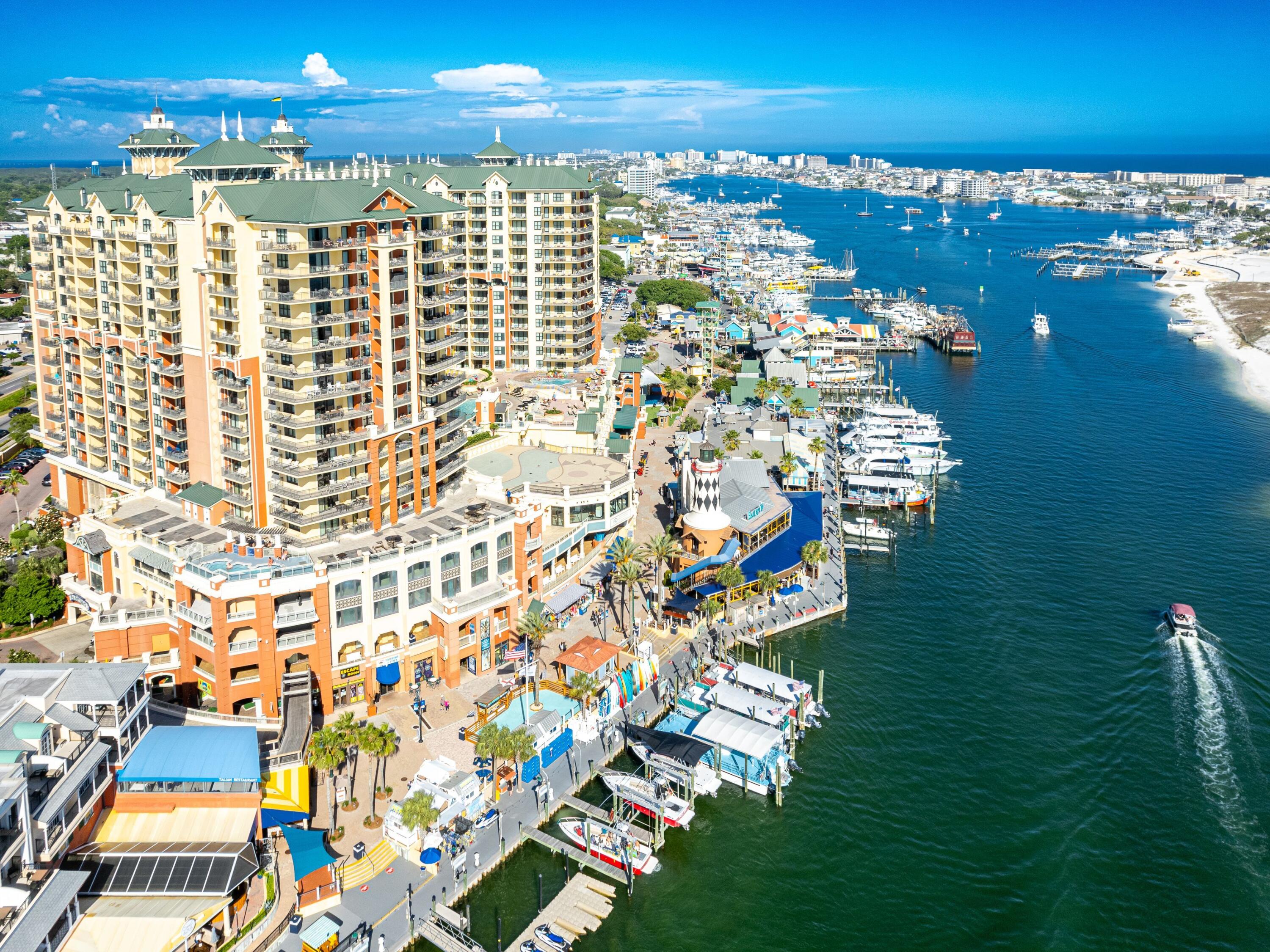 This prestigious three-bed, three-bath condo is in the landmark Emerald Grande building in the heart of Destin Harbor. The generous balcony overlooks Crab Island and the colorful boats coming and going in bustling Destin Harbor and the East Pass. Stunning views are a given, especially at sunset. This luxurious residence is on the main pool level, convenient for all amenities including the pool, bar, restaurant, sun terrace, exercise room and front desk. A huge hot tub offers superb East Pass views from the swirling spa waters. From the entrance hallway, the accommodation stretches past the open kitchen and dining area to a comfy sitting room with updated furniture. New flooring, fresh paint, and updated coastal furnishings add to the vacation ambiance. Take a seat at the sweeping bar or put your feet up in the living area and enjoy stunning views through a wall of sliding glass. The kitchen is beautifully appointed with wood cabinetry, granite countertops and updated stainless appliances. Warm LVP flooring continues into the bedrooms with tile in the kitchen, hallway and bathrooms. The spacious master suite includes a lavishly appointed private bathroom with corner soaking tub and granite-topped twin vanity. It also boasts an oversized walk-in shower. There's a second king-sized master suite, also with a private bathroom. The third bedroom has a queen bed and bunks, providing ample space for family and friends to vacation together. Sliding doors to the balcony deliver additional private space with amazing views. Amenities at the Emerald Grande are hard to overstate, starting with a foyer that would grace any five-star luxury hotel. The front desk provides easy check-in for renters and guests and is a source of local information. Leave your car in the garage and stroll along HarborWalk Village, taking in the endless choice of bars, restaurants and gift shops. You don't have to venture far to find a host of shopping and dining along the attractive waterfront, just steps from the condo. For a relaxing beach day, take the water taxi to the beach and relax on the beautiful white sand. For those in search of an iconic condo as a second home or lucrative rental property, nothing says "vacation" better than this. High-level amenities, updated interiors, and the ultimate location ensure the highest levels of desirability for owners, renters and guests.