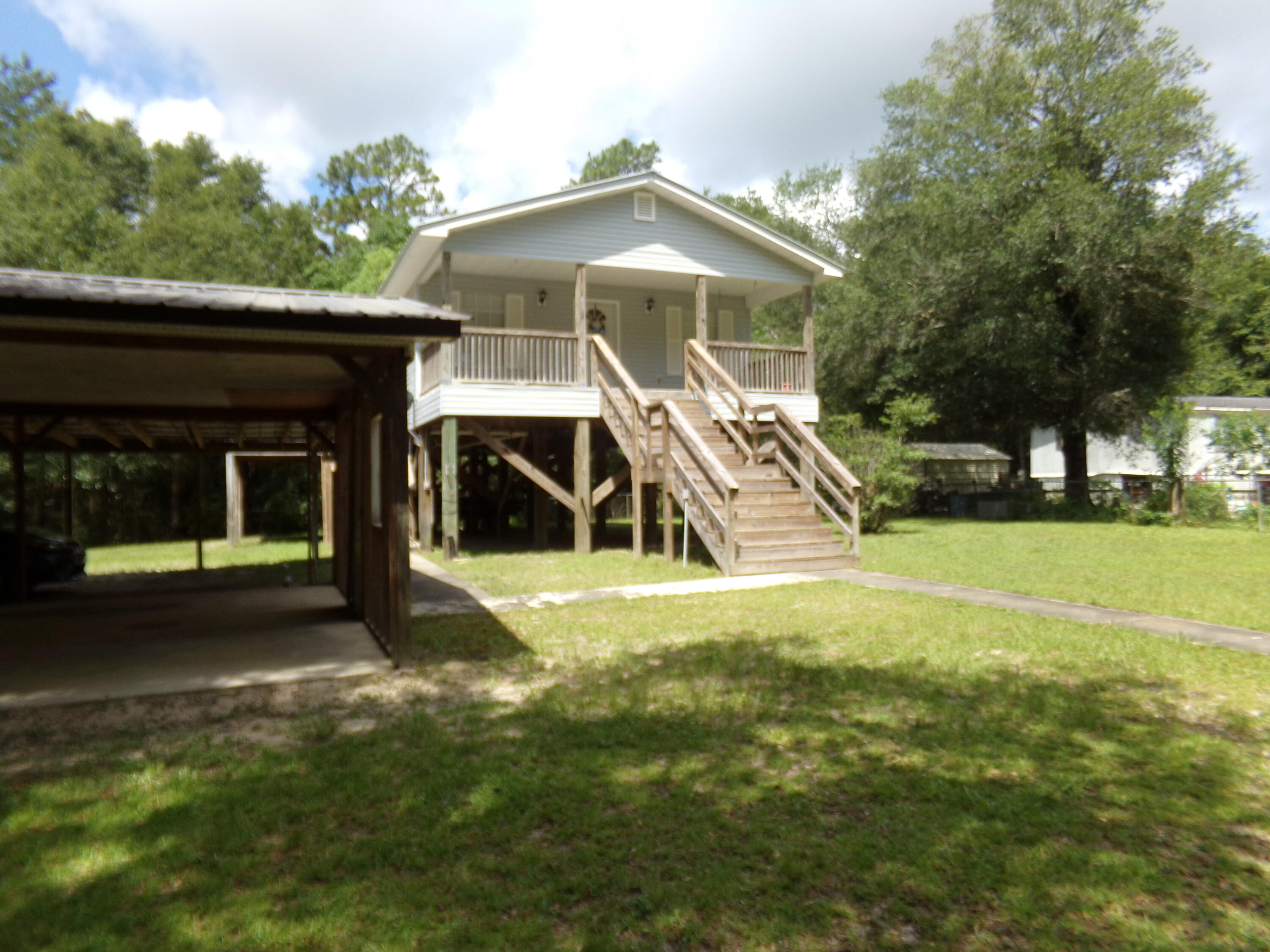 Looking for a home or get away with a clear creek ~ This home is on stilts with the yard fully fenced, chain link~ Covered Front porch to enjoy the quite and fresh air~ Porch off the kitchen just perfect for outdoor dining~ Guest Lake public boat launch for Yellow River is just down the road, the creek on the property flows into Yellow River~ There are 2 wells on the property, not being used~ Holt water & Chelco Electric~ The HVAC was replaced in 2019, new metal roof in 2020~ 2 Bedroom, 1 bath~ All appliances including washer and dryer~ Kitchen has plenty of cabinets and counter space~ A large bath room which has a large garden tub, separate shower, double vanity and a single vanity as well~ There is power to the outside patio~