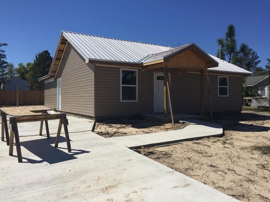 Back Yard is being privacy fenced. Concrete driveway and parking pad to accomodate up to 4 vehicles, Granite countertops. Both Baths are FULL with tub and shower. This s a NEW Home Under construction. Will have to be finished prior to occupancy, Ceiling fans in all Bedrooms and Living Room. Front Porch. Metal Roof is Galvalume, Vinyl Siding and Soffit. ONE Year Contractor warranty on all workmanship and materials used. Vaulted ceilings in LR Dining room combination. All stainless steel appliances in kitchen. Prodex insulaton barrier under roof and outer walls for added protection from the elements. Built to CODE!! Beautiful Home inside and out! Let's make it yours.