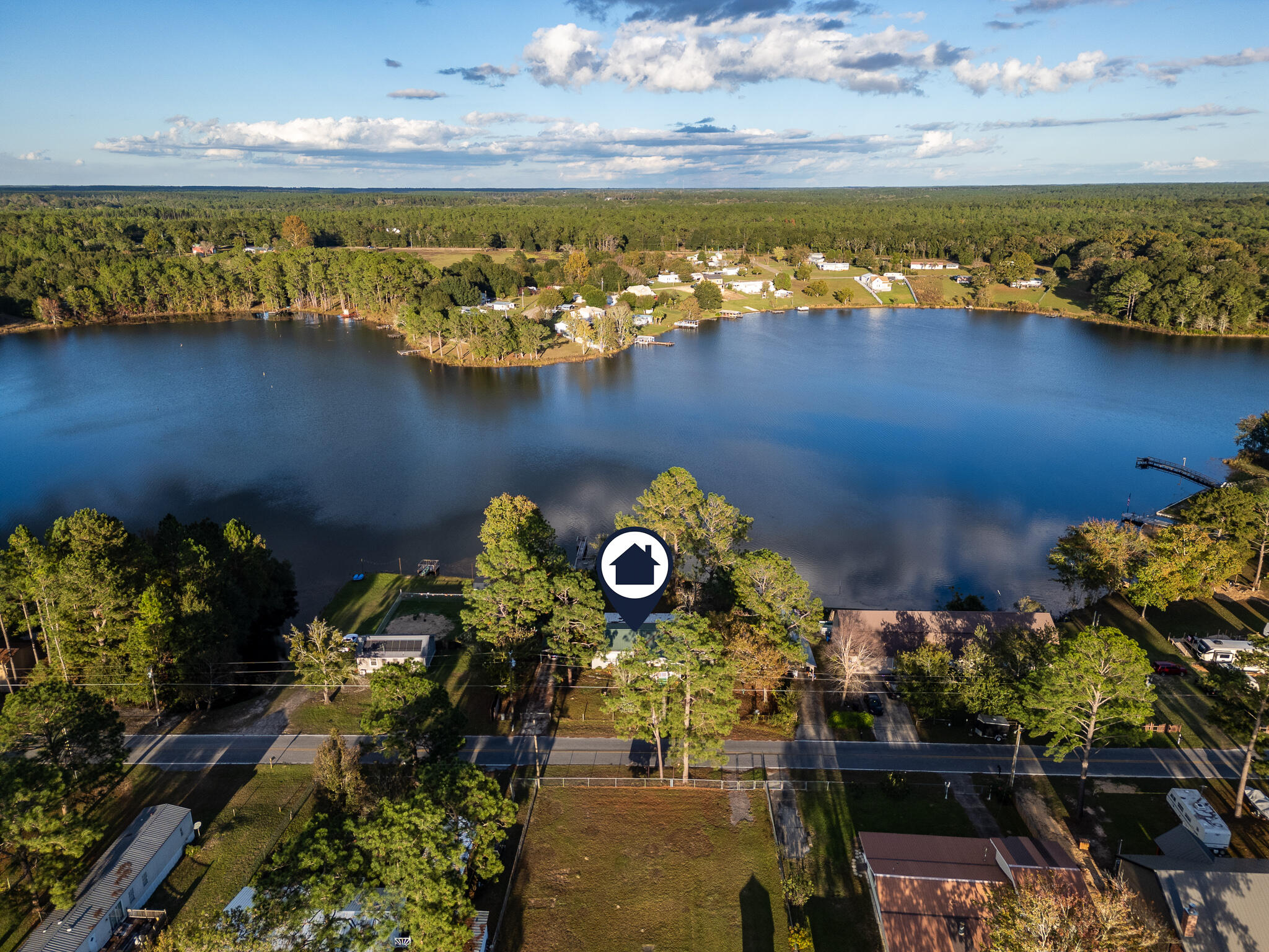 Lakefront living at it's finest! With over 135 feet on King's lake you will enjoy the wonders of island living with the sun rising on the front of the home and beautiful sunsets from the enclosed back porch. Fish  off the dock or launch your boat directly from your own launch. The lake is teaming with fish for the avid angler to enjoy endless days fishing. The home is has been meticulously maintained and is in great condition with a newer metal roof (8 years old) and HVAC system with new air ducts.. You will enjoy peace and quiet in the yard with an lovely assortment of fruit trees, peaches, fig, lime, oranges and a blueberry bush. Storm windows for entire house. Covered front porch 10 x 18. Fully fenced yard. Property is lake front and just under ?? acre. Bulkhead around water's edge. Two 12 x 12 decks on lake one on each side of water's edge (north and south). 32' fishing pier on north side. 14' wide boat ramp on north side leads to covered boat dock.Separate metal shed for fishing gear.  Snap-on hurricane panels for entire house. Two storage sheds. Located on quiet, paved, dead-end road. 