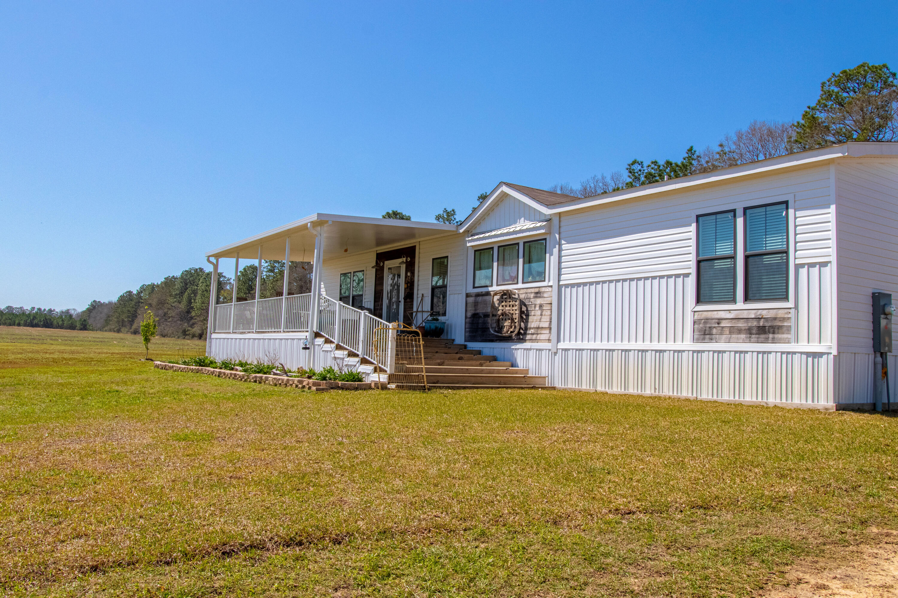 Nestled on 10 picturesque acres, this immaculate and custom mobile home offers a serene retreat with direct access to Blackwater State Forest.  Featuring a thoughtfully designed split floor plan and numerous upgrades, this move-in-ready home provides both comfort and style.  Large kitchen with stainless appliances, breakfast bar and large living area.  Large master suite with dual sinks.  All bedrooms are good sized with plenty of storage.  The property includes: Spacious 12x32 shed for storage or workshop needs, Large carport for covered parking, Pump house with a well and purification system, and a brand-new tractor--conveyed with the sale!  Don't miss this rare opportunity to own a beautiful home surrounded by nature. Schedule your showing today!