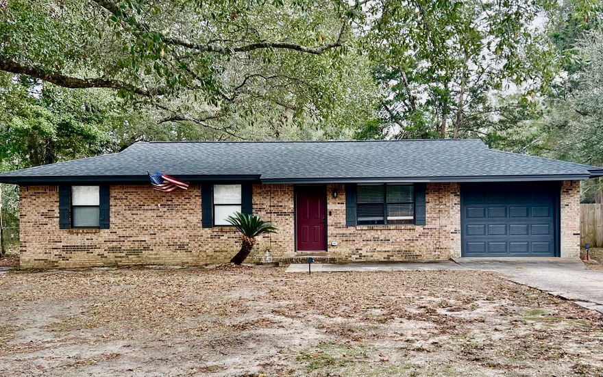This beautifully updated 3-bedroom 1-bath all-brick home that was fully remodeled in 2023 and is truly move-in ready. Updates include a new metal roof, HVAC system, hot water heater, stainless appliances, and flooring throughout. The main living areas feature durable vinyl plank flooring, while the bedrooms offer plush carpet that still looks brand new. The kitchen has been completely remodeled with a farmhouse sink, gorgeous countertop and modern finishes. The bathroom has also been fully renovated, offering a fresh, updated feel. Enjoy indoor-outdoor living with a sliding glass door leading to a large screened-in back porch.  Additional features include a spacious laundry room, plantation blinds, and a one-car garage that is finished with heat/cooling.  Fenced in backyard