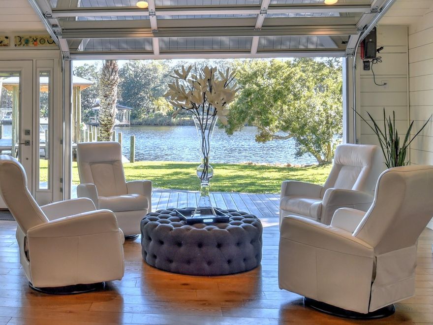 This is surely a rare find.  Situated on a peninsula at the end of the street with 260' of deep water. Have a big boat?  No problem here!  The boat slip will accommodate a 30' boat.
The clear glass garage door opens up bringing the outside in.  Perfect for enjoying all the nature around such as a pair of resident bald eagles, birds diving in the water, dauphins playing in the bayou, and boats going by.
The open floor plan features white oak wood floors, shiplap walls, and ceilings, and lovely lighting gives this home such a peaceful and tranquil fill.  
The kitchen features European style cabinets, upgraded appliances, a prep sink along with the main sink.  The custom barn doors open to a pantry with wood shelving on one side and storage space on the other side.
With a split floor plan there is a bath and large bedroom off of the living area.  On the other side are 2 large bedrooms overlooking the water with a door leading out to the covered porch.

The guest bath has a stand-alone 70" tub is the perfect soak at the end of the day along with a separate shower.
On the backside of the house is a large room with wood tile flooring perfect for a home office, craft room, or anything you wish it to be.
On the backside of the house, you will find an additional lot with a climate-controlled 12x20 workshop.
Just a short distance by car or golf cart to Grand Blvd and offers everything you need, Publix Market, Restaurants, and great shopping or catch an afternoon movie.  And of course close to our beautiful beaches.
There are so many upgrades there are too many to mention.
This sounds like a dream, but let me pinch you!  It's not!