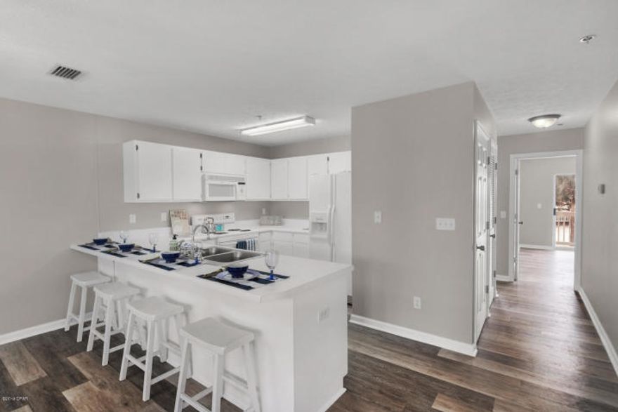 Beautiful MOVE IN READY featuring new plank floors and paint throughout. Less than 700 ft from the beach - amenities include community pool, Gazebo/Picnic/BBQ area, and shuffleboard. This 2nd floor end-unit offers an open floorplan with a wrap-around covered balcony, additional windows, owner's closets indoors and outdoors, breakfast bar, Mbth double vanity. This unit makes a great vacation home , rental investment, or primary residence. This low rise complex also has an elevator for convenience. ALL MEASUREMENTS SHOULD BE VERIFIED IF IMPORTANT.