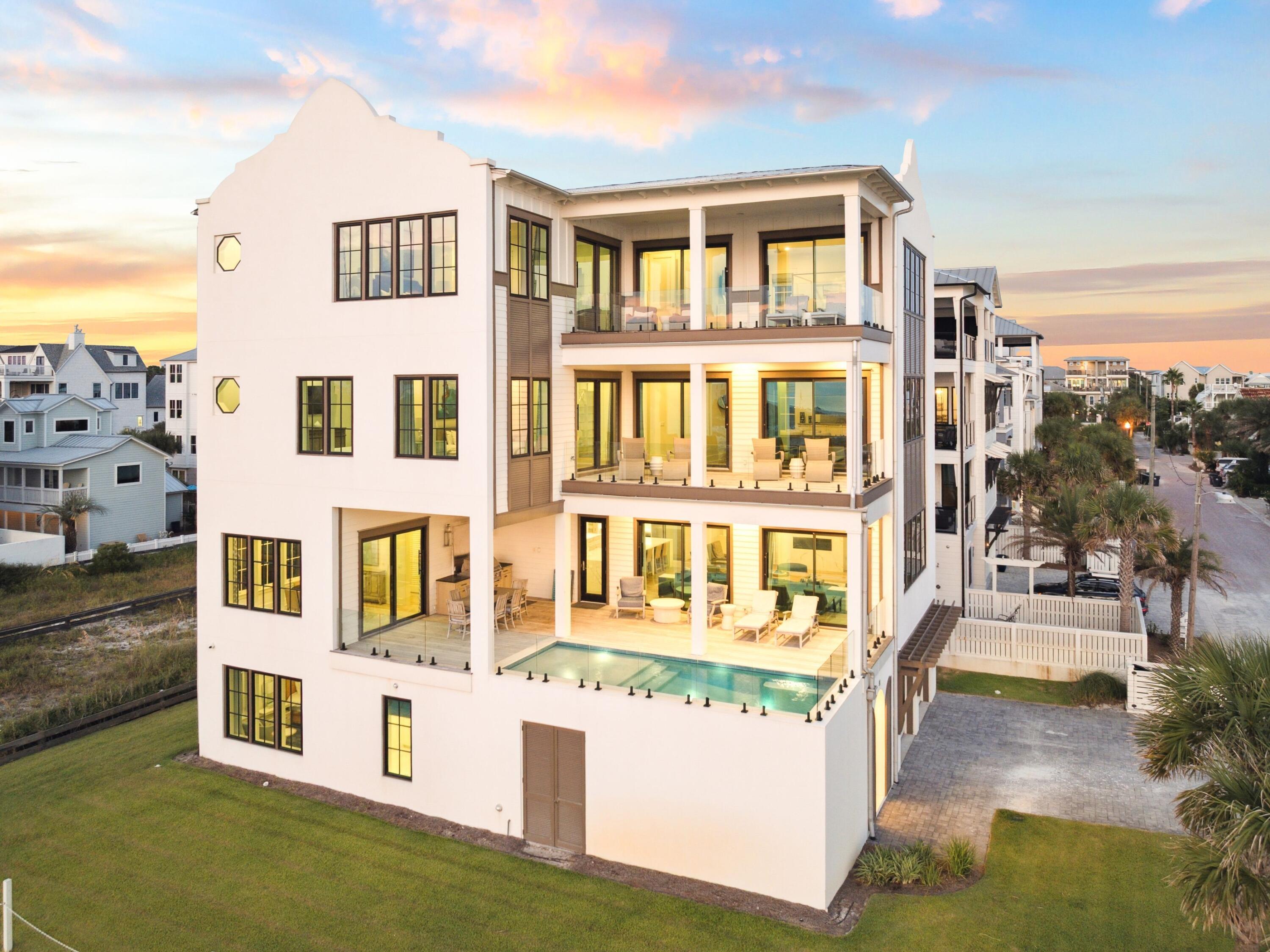 Nestled in an idyllic location overlooking protected dunes with stunning forever Gulf views, 91 Emerald Cove Lane presents an unparalleled opportunity for luxury living. Thoughtfully positioned on a prime corner lot in Inlet Beach, this residence ensures unobstructed vistas of the Gulf from every level, with sweeping views enjoyed from all living spaces. Spanning more than 7,600 square feet across four levels, the home is designed for both grand entertaining and private retreats. A welcoming foyer introduces the main level, featuring a spacious primary suite, a billiard and game room, and a private owner's lockout. The second floor serves as the heart of the home, where expansive living and dining areas flow seamlessly to a resort-style pool terrace. A gourmet kitchen with crisp white cabinetry, a statement island, state-of-the-art appliances, and custom lighting anchors the space, while a full laundry room adds convenience.
Guest accommodations are abundant, including a private guest suite with en-suite bath, a custom bunk room with its own bathroom, and another guest suite overlooking the dunes. A secondary living and game area with shuffleboard completes the third floor. The top level is dedicated to two remarkable primary suites, each capturing panoramic Gulf views with en-suite baths and walk-in closets. One retreat features a spa-inspired bath with a soaking tub perfectly positioned to take in the breathtaking scenery.
With six bedrooms, six and a half baths, covered balconies on every floor, and refined details such as crown molding and wood flooring throughout, this home blends modern luxury with timeless coastal beauty. Just steps from the beach walkover and moments from 30A's best dining, boutique shopping, and entertainment, 91 Emerald Cove Lane defines the pinnacle of Gulf-front living.