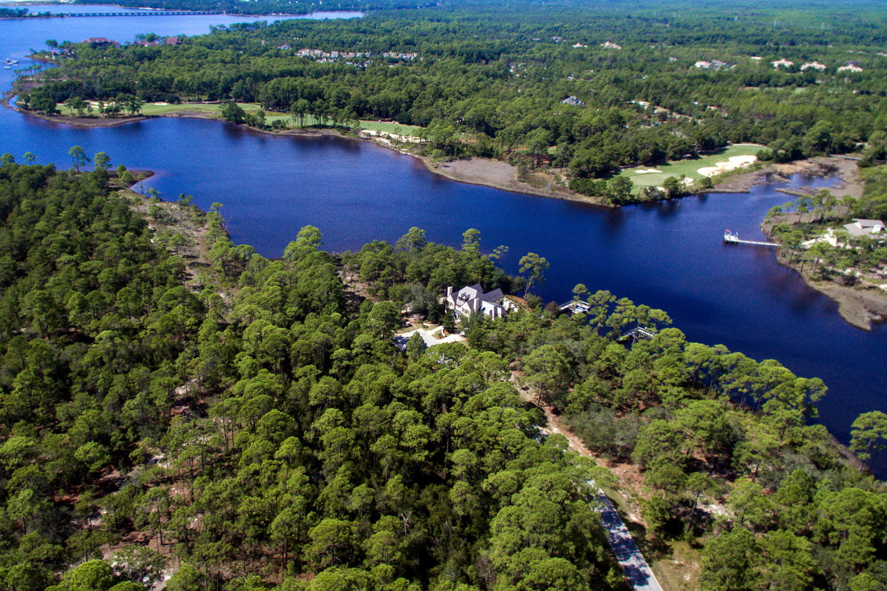 This waterfront lot with 143 feet on Lake Powell offers just over half an acre on which to build your custom designed home. Assured views of Lake Powell, the largest coastal dune lake in Northwest Florida, this lot will also appeal to the golf enthusiast, capturing views of hole number 5 at Shark's Tooth Golf Club. The Greg Norman designed private course meanders around Lake Powell and forests, with scenic elevation changes. Construction of a dock on Lake Powell is permissible.