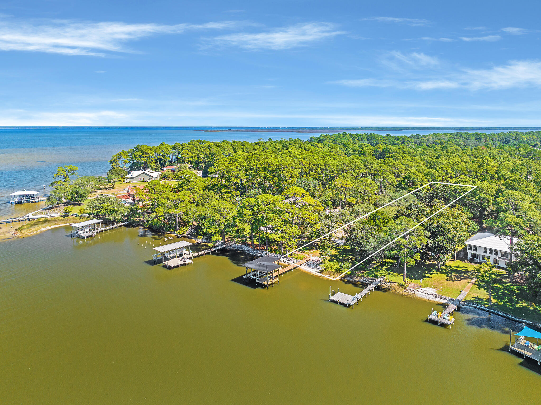 Deep water lot on picturesque Hewett Bayou with bay views and a brand new dock and boat lift. Boasting just over 82 feet of prime water frontage, new riprap, a beach entry, and no HOA, this beautiful homesite has been carefully cleared to capture the sparkling bayou and bay views from a cathedral of oak trees and spanish moss. No need to start from scratch for a new build. Plans for a 6,000+ sq ft custom designed home with a pool, summer kitchen, and three car garage are also included and already in permitting. Survey and design selections from The Luxe Designer available. Bayou living offers a serene setting to watch spectacular sunsets and dolphins. Paddleboard and kayak just steps from your back door. Discover this captivating retreat on Hewett Bayou with the coveted convenience of quick, direct access to Choctawhatchee Bay and the Gulf of Mexico, yet protected from open waters.