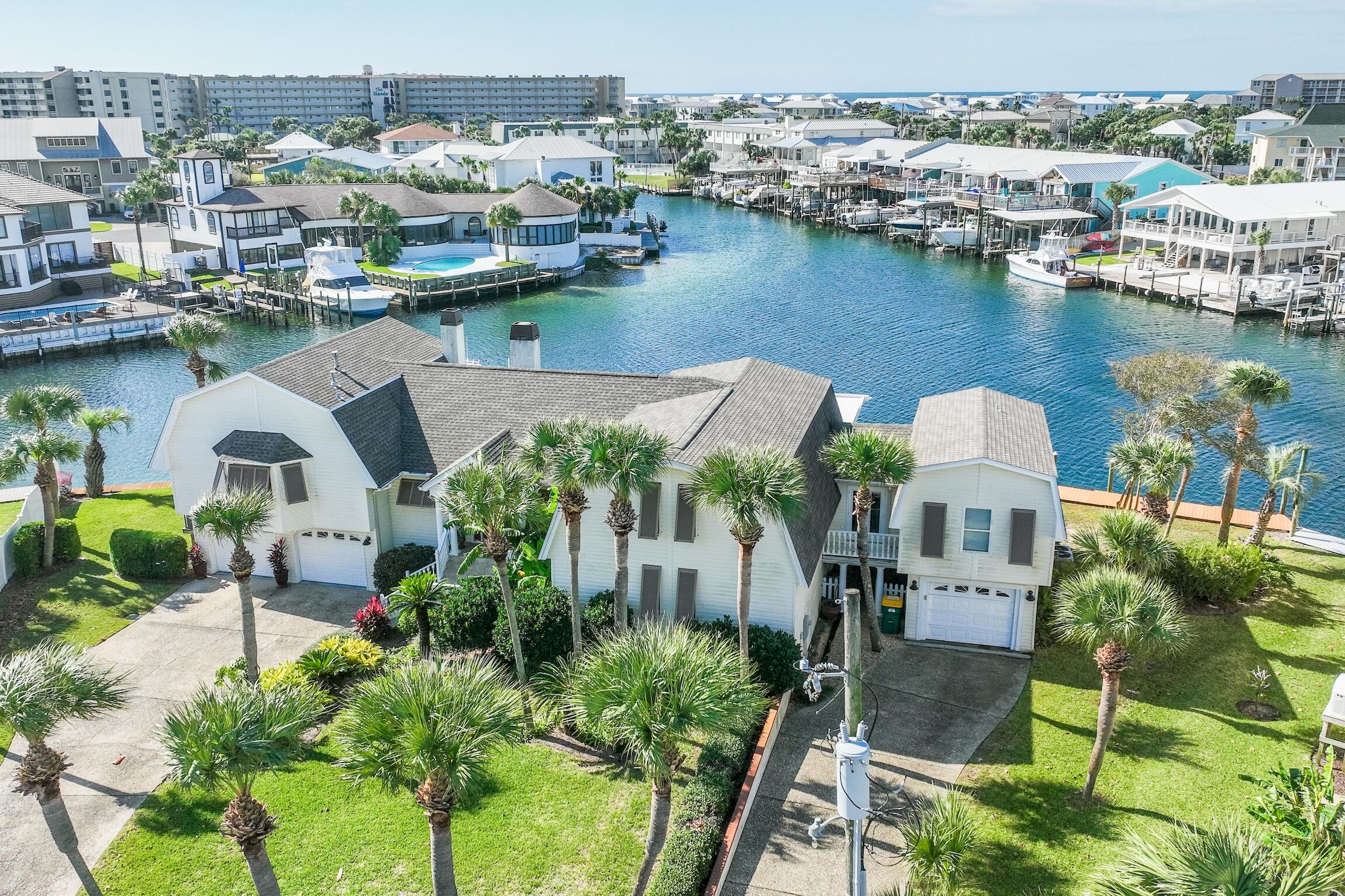 This lot is one of the largest lots on Holiday Isle with 180 ft. of water frontage!!! Got an extra large boat? Space for yacht dockage is ample. In addition to the lenghty seawall, the property also boast two 35 ft. boat slips. The home is over 3600 sf with 4 bedrooms and 4.5 baths. The property has two primary suites, two guest rooms and an office. The kitchen has been updated with granite counter tops, stainless appliances with a subzero refrigerator, viking stove, microwave and dishwasher. For all the wine lovers, the home has a wine cooler fit for a king. The property has multiple decks and porches for entertaining on the water, plus the yard is large enough to install a pool. Holiday Isle has deeded beach access just a short walk away. This could be the home of your dreams!