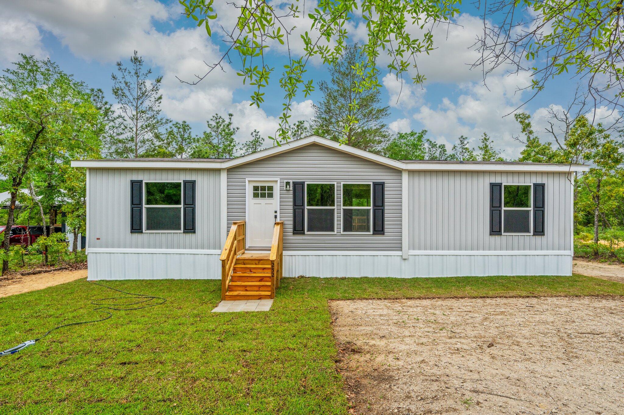 Be the first person to live in this brand new 3 bedroom, 2 bathroom manufactured home nestled on a spacious quarter-acre lot. This property features an inviting back porch--perfect for morning coffee or relaxing evenings outdoors.Inside, this home is unlike other manufactured homes with an upgraded kitchen including stainless steel appliances and vent hood, a french door refrigerator and custom color cabinetry. Off of the kitchen is a coffee bar and laundry room. The split bedroom floor plan offers privacy for the primary suite. The beautiful green cabinet color flows from the kitchen into the master bathroom where there is a double vanity and a walk-in shower. The large yard offers plenty of room for gardening, outdoor play, or future upgrades like a workshop or carport.