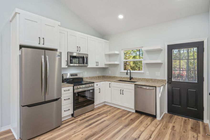 This new construction home is serving up charm on 1.31 acres. Construction is complete and it's move in ready! Nestled on a county maintained road & the curb appeal is on point with fresh sod landscaping, a covered front entry, and a concrete pad, covered back patio. Need parking? No problem. The gravel pad has you covered with plenty of parking space. Wrapped in classic board & batten, Hardie Board siding and topped with a sleek black metal roof, this beauty was built to last. Step inside to an open living space. The living & kitchen areas have vaulted ceilings with the bedrooms and bathrooms all featuring 9' ceilings. If an airy & spacious feel is what you are looking for, this one meets that goal! Luxury vinyl plank flooring runs throughout with shaker style cabinets, granite countertops, and stainless steel appliances. The split floor plan has the master suite off to one side of the home with a double sink vanity & shower-tub combo, while on the other side of the home, sits two more cozy bedrooms cradling another full bathroom. Ceiling fans are placed in ever bedroom and the living area with some recessed lighting throughout. With the spacious property being over half an acre, there's plenty of room to explore options for desired outbuildings. This home was built beautifully and is a must see! Contact your favorite realtor to schedule a tour.