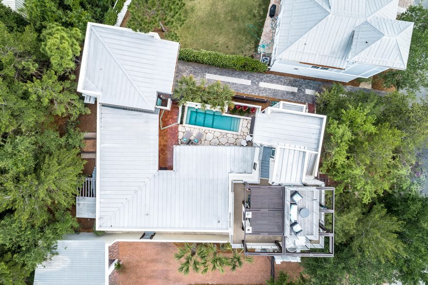 The epitome of coastal chic, this contemporary 5BR/5.5BA Rosemary Beach home features a welcoming and open design that makes every day feel like a celebration. Two living areas connect to a dining area and luxurious chef's kitchen providing space for guests to spread out and relax. A sleek covered lanai with outdoor fireplace leads to a striking private swimming pool with three spill fountains flowing from a stacked stone wall. A third-floor rooftop deck with both covered and open spaces to lounge is the perfect place for soaking up refreshing Gulf breezes. Follow the spiral staircase to a fourth story viewing tower with spectacular, panoramic community views stretching to the Gulf of Mexico. A refined, modern style defines all the interior spaces where you'll find luxury finishes such as stained concrete floors, custom cabinetry and built-ins, beautiful tiled bathrooms and designer lighting. Two comfortable guest suites are located on the first floor while the elegant master suite and an additional guest suite are on the second level. A separate carriage home over a garage with bedroom and full kitchen is ideal for hosting guests or as a home office.  The unique and thoughtful features of this home allow it to serve well as either a primary home or an investment property. Currently on a rental program, it is popular with wedding parties. Designed by Miami-based Duany Plater-Zyberk and Company, Rosemary Beach embraces the principles of traditional town planning with a pedestrian friendly design. With its brick-lined streets, charming town center, unique shops and locally-owned cafes, locals and guests alike delight in this picturesque 30A community.