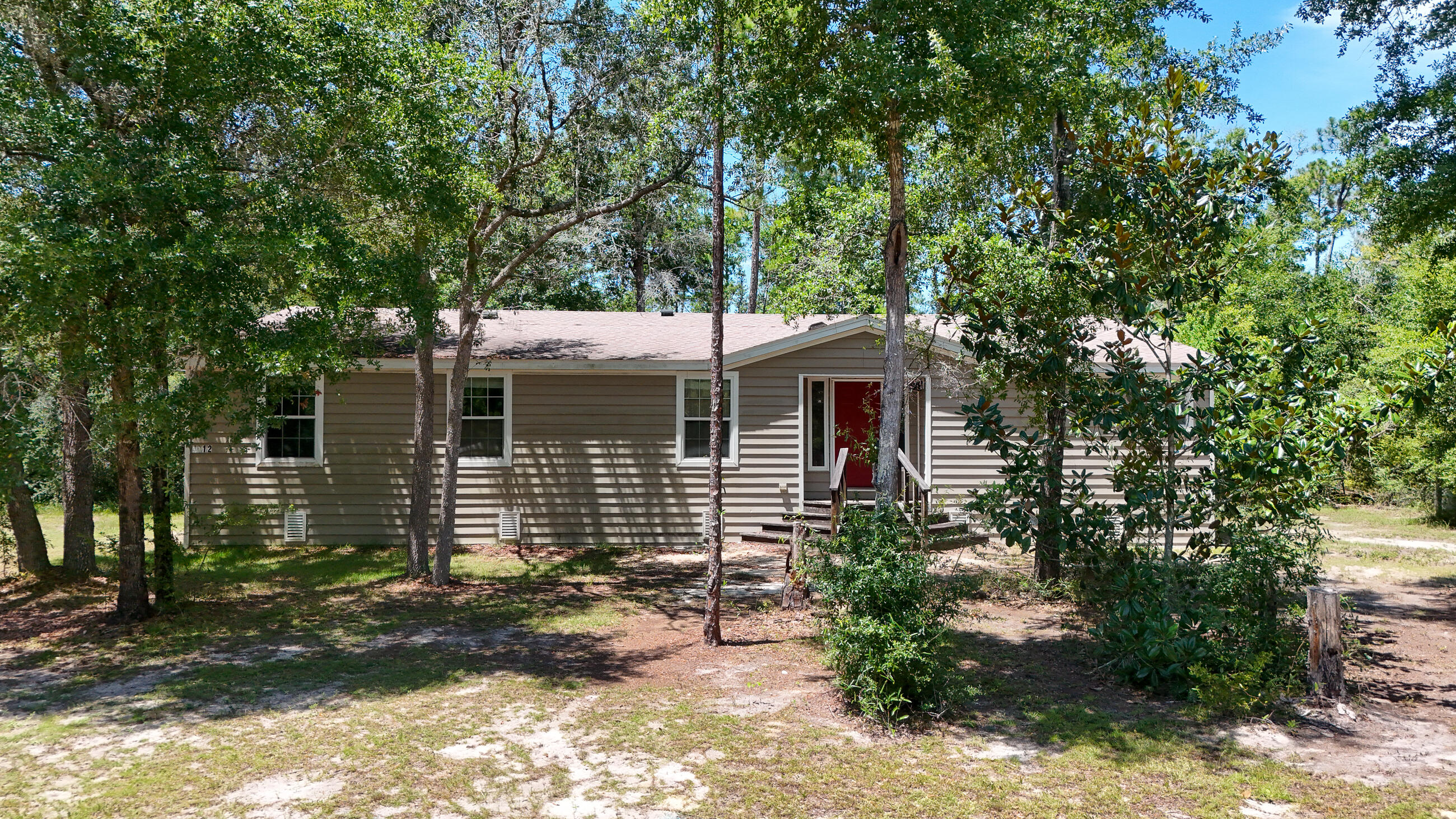 This unique property offers a rare combination of long-term passive income and development-ready land in a growing area of Panama City. Situated on over 19 acres, with approximately 5 acres of usable land, the property includes a cell tower lease that provides monthly income with annual increases, providing a built-in revenue stream from day one. The tower is strategically placed on a non-developable portion of the land, preserving full use of the developable acreage. At the heart of the property sits a spacious 5-bedroom, 3-bath triple-wide mobile home featuring durable LVP flooring, crown moulding, and an open living area with a cozy fireplace. The large kitchen has an island, ample cabinetry, and generous counter space. Large windows fill the home with natural light. (SEE ADD REMARKS) Surrounded by mature trees, the land offers both privacy and potential for many outcomes, whether you're looking to add multiple mobile homes, build new construction, or create a small subdivision. The location is wonderful, being just minutes from Deer Point Lake, Lynn Haven shopping and dining, and within 20 miles of the white sands of PCB, this property is ideal for investors or anyone looking for space, flexibility, and built-in income.