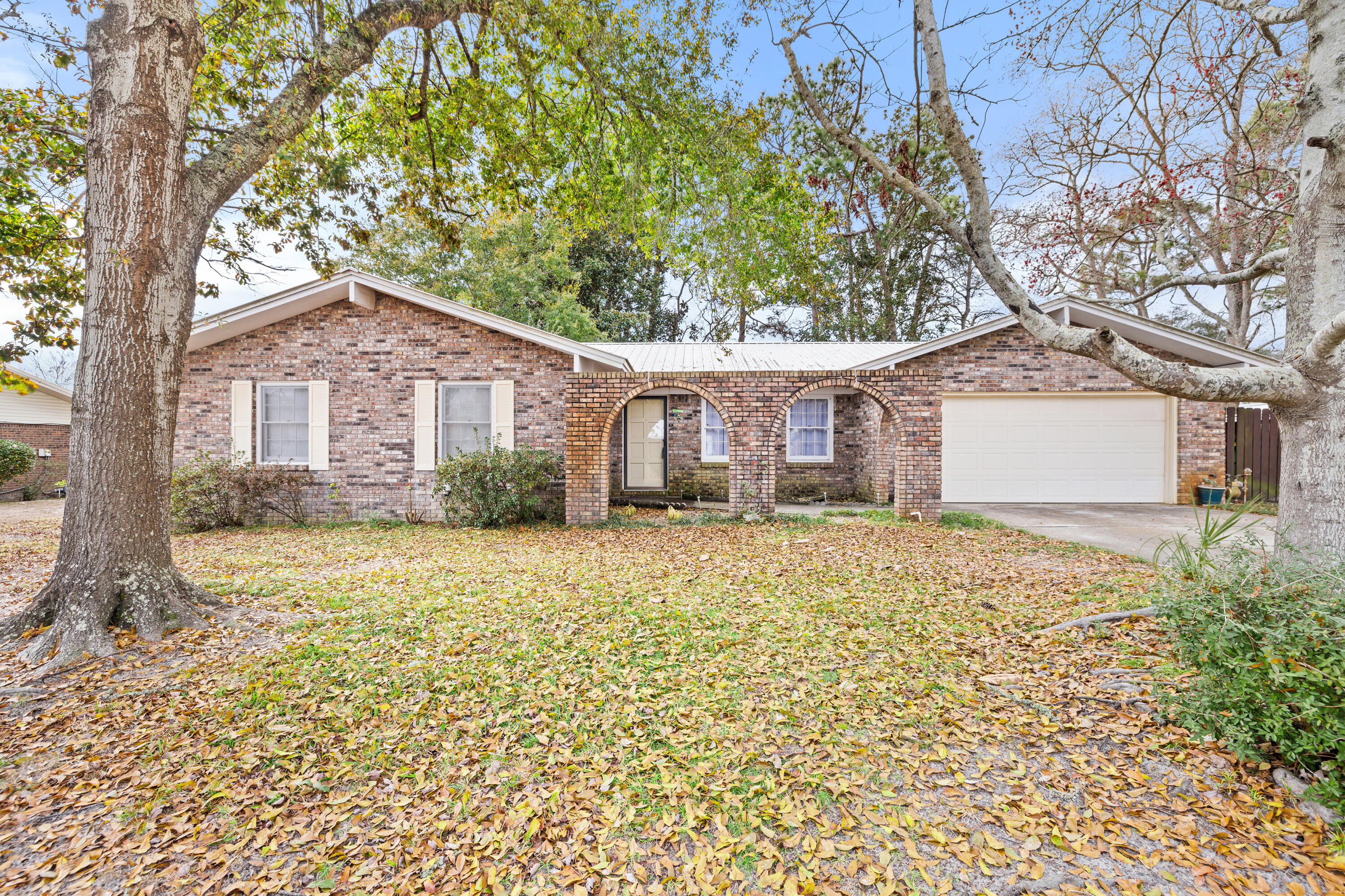 Nestled in the established neighborhood of Palm Estates, this all-brick home offers a warm and inviting atmosphere with its classic charm and location conveniences.Upon entering the home, the living room is the heart of the home which features a gas fireplace that adds warmth and ambiance to the space. Winding down these last few chilly winter evenings, this area is perfect for snuggling up with your favorite book or tv program. This room was designed for an opportunity to have extra furniture or sectioned off to accommodate a computer desk area or child's play corner area.The kitchen provides the family cook with plenty of counter and cabinet space, making daily meal preparation a cinch. (Click 'Read More' for balance of description) Whether you're cooking for a family holiday gathering or a quiet night in, this kitchen has everything you need, extra counter space, tons of cabinet storage, pantry and a dining area looking out to the shaded backyard. The large laundry room is a standout feature, it offers some shelving space above the washer and dryer for laundry detergent, etc. There is room enough to add a base cabinet beside the washer to make it an area for prepping and folding laundry. Additionally, there is room enough to add a freezer if you were to slightly modify the two storage closet areas.
The home is equipped with a durable metal roof and a newer 75 gallon water heater, ensuring longevity and efficiency. However, the home does need some TLC as it hasn't been updated outside of the master bathroom. It has a new walk-in shower which was constructed in late 2024. This house provides you the opportunity to choose your own flooring options, paint colors, updated appliances and more if you choose. The property boasts a large privacy fenced-in backyard adorned with numerous mature shade trees, providing a serene and picturesque setting. Ideal for outdoor enthusiasts, the screen porch extends your living space, allowing you to enjoy the outdoors comfortably. Conveniently located close to Palm Plaza and Oak Creek shopping centers. This home offers easy access to everyday amenities such as educational and recreational facilities, making it an ideal neighborhood for families and professionals alike.
This charming brick home seamlessly blends comfort, convenience, and traditional appeal, making it a perfect place to call home.