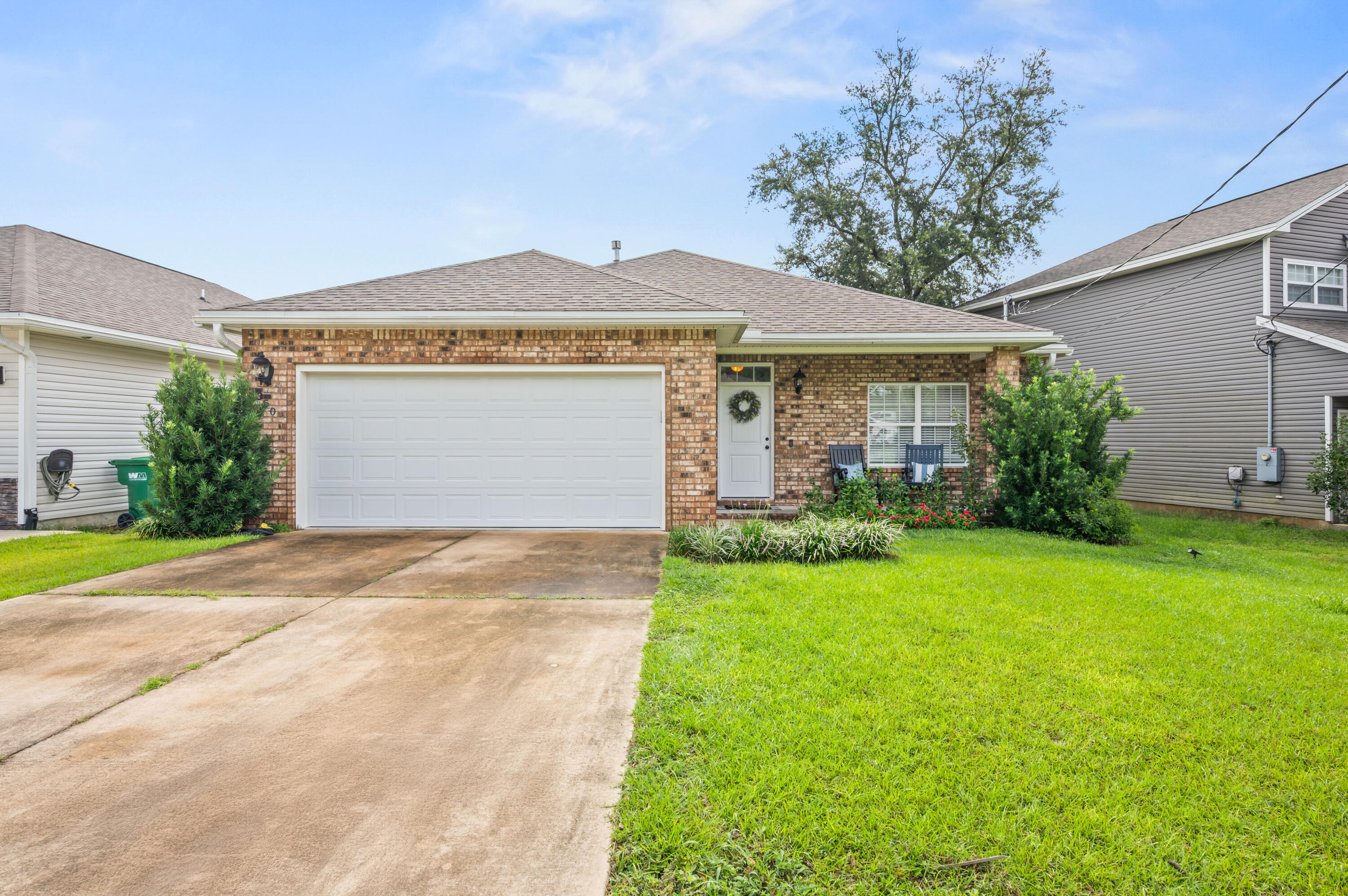 Charming All-Brick Home with Modern Comforts & Prime Location! Welcome to this beautifully maintained 3-bedroom, 2-bathroom all-brick home, perfectly blending timeless style with everyday convenience. Step inside to discover easy-to-maintain tile flooring throughout--no carpet anywhere! The bright, open layout creates a warm and inviting atmosphere, ideal for both relaxing evenings and entertaining guests. Enjoy your morning coffee or unwind after a long day in the screened-in back porch, complete with tile floors, overlooking the private backyard which backs to a green space. Step out to your 10' x 24' low maintenance composite deck complete with a privacy wall and added Clumping bamboo for an outdoor BBQ oasis feel. The spacious 2-car garage provides plenty of storage, while the home's central location near top-rated schools, parks, and local amenities makes daily living effortless. With its solid construction, thoughtful updates, and unbeatable location, this home truly checks every box!