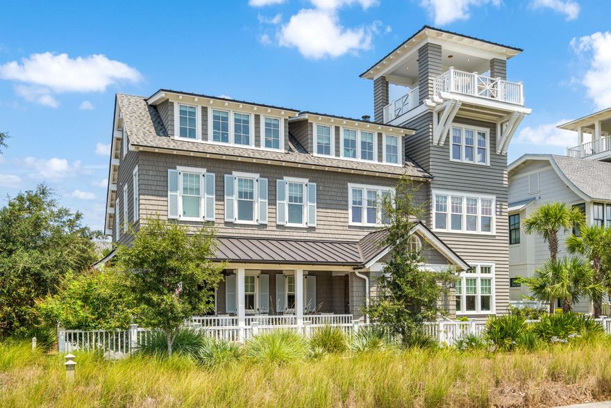 Indulge in a life of coastal luxury at this exquisite WaterSound Beach residence nestled on a premier corner homesite with over 6,000 square feet, 6 bedrooms, 7 full and 2 half bathrooms, a private pool courtyard, incredible Gulf of Mexico views, an attached two-car garage, and so much more. The classic Nantucket-style exterior welcomes you into stunning interiors expertly appointed by designer Suzanne Harman. A covered front porch leads into a beautiful foyer with a grand curved staircase. Notice the contrast between the white coffers and wood paneling in the ceiling in the expansive living and dining areas featuring a brick lined wood burning fireplace, built-in cabinetry and shelving with wood panel accents, a wet bar, and abundant natural light. From this gathering space, access a