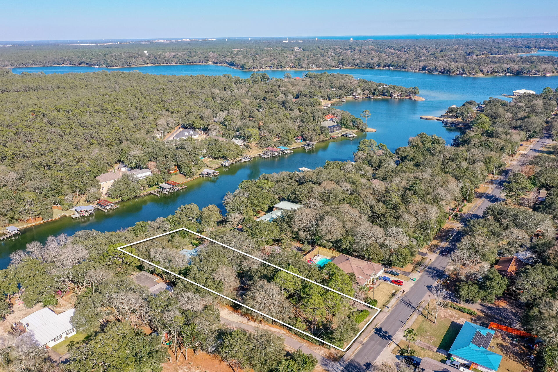 ACT NOW - Affordable, bayou front home in Kenwood on deep water on large, gorgeous .71 acre lot! Nestled amongst majestic Oaks, fruit trees & natural foliage , relax & unwind as you enter thru the gates.  Renovations to original design, include large, floor to ceiling windows which provide beautiful Bayou views throughout. The spacious, remodeled kitchen w/newer cabinets & huge granite eating bar is the heartbeat of the home & flows effortlessly onto the 425sf screened porch. After waking to serene water views, take an early AM paddle board ride before hopping on your boat for a day on the water! The new dock w/covered slip makes it east to enjoy the waterfront lifestyle. Metal roof, 3 year old HVAC provide peace of mind. Other features include gas fireplace, handicap accessible