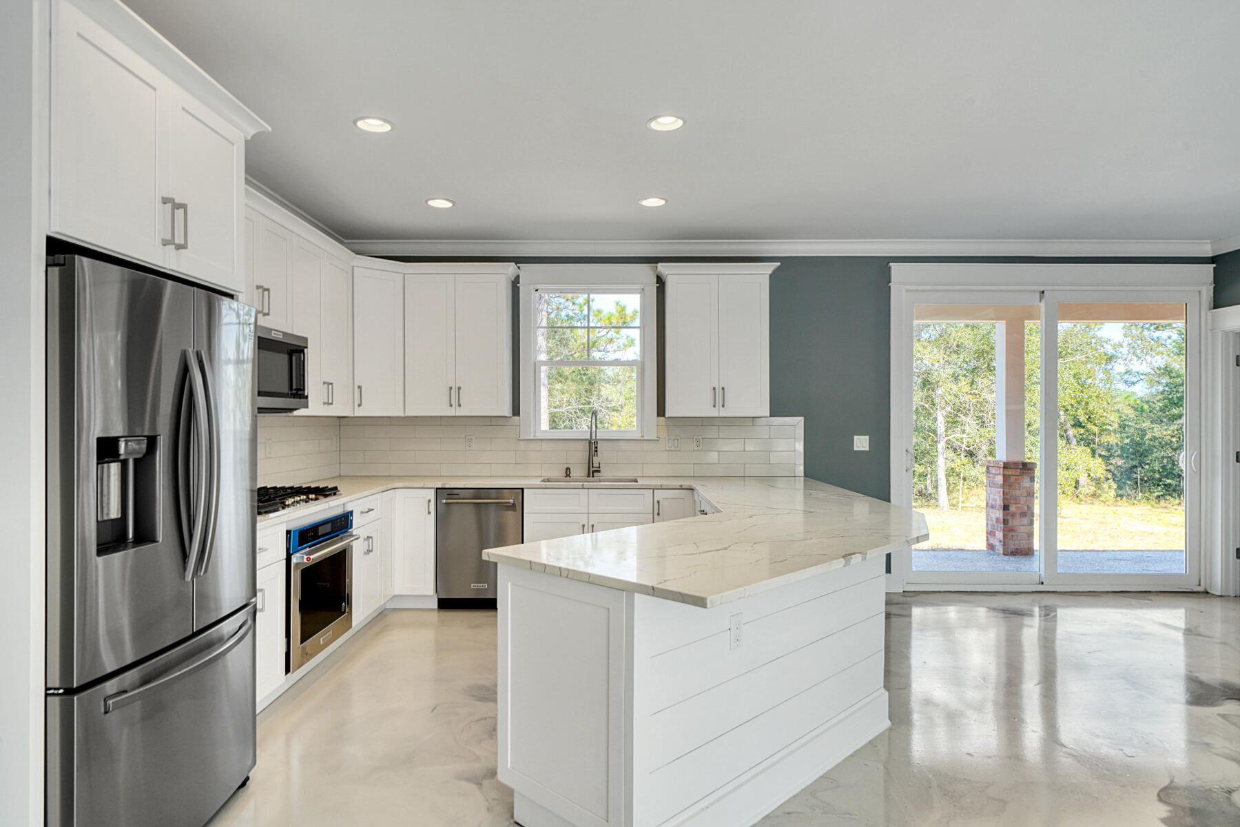 Uniquely Amazing Custom-Built 3 Bedroom/2.5 Bath, 1654 sqft Brick Home (2021) sits on a large approximately 1-acre property in DeFuniak Springs FL. No HOA. From the moment you drive up to this spectacular home, you are greeted with a beautiful paver driveway and sidewalk. As you walk into the front door, you will be dazzled with the marble epoxy glazed flooring, 9' ceilings with crown molding & wide baseboards throughout the home. The very spacious kitchen boasts gorgeous granite countertops, lots of beautiful cabinetry with crown molding and Kitchenaid(r) stainless steel appliances. The large open concept living/dining and kitchen areas offer plenty of space to relax. Venture into the Master Bedroom and check-out the outstanding master bathroom featuring oversized tile shower with glass