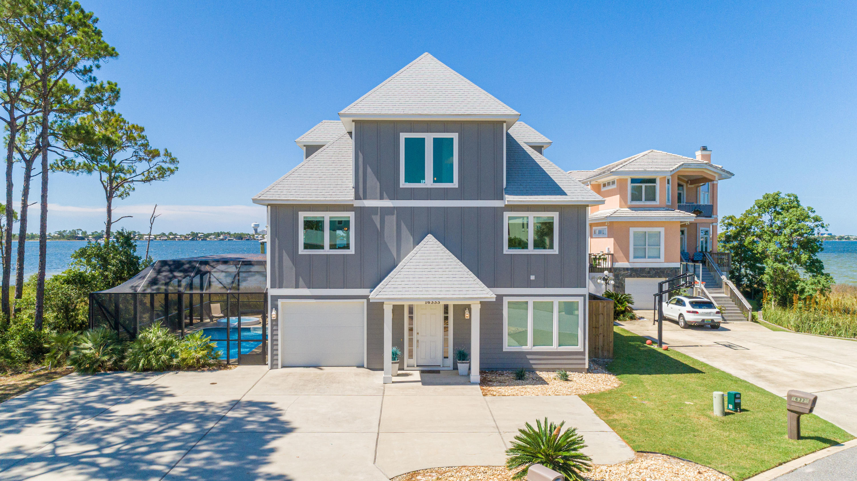 Situated in the gated community of Russell Bayou on Innerarity Island, this custom-built home offers wonderful views of the Bay and Ono Island with 89 feet of water frontage. This home comes equipped with a dock and boathouse, power & water housing 3 spigots, 10,000 pound boat lift (with remote control) with a 30 foot boat slip as well as a convenient fish cleaning station and your very own private beach! Upon entering, you'll note the abundance of natural light, open spacious floor plan with an ELEVATOR to all 3 levels. You'll also enjoy 3 levels of outdoor living/entertaining space which has a 37'x8' covered balcony right off the main living area. The lower level has a screen enclosed porch as well as saltwater pool with a hot tub. The well appointed kitchen has granite countertops, larg