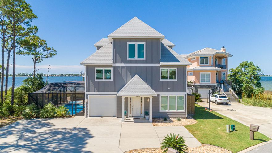 Situated in the gated community of Russell Bayou on Innerarity Island, this custom-built home offers wonderful views of the Bay and Ono Island with 89 feet of water frontage. This home comes equipped with a dock and boathouse, power & water housing 3 spigots, 10,000 pound boat lift (with remote control) with a 30 foot boat slip as well as a convenient fish cleaning station and your very own private beach! Upon entering, you'll note the abundance of natural light, open spacious floor plan with an ELEVATOR to all 3 levels. You'll also enjoy 3 levels of outdoor living/entertaining space which has a 37'x8' covered balcony right off the main living area. The lower level has a screen enclosed porch as well as saltwater pool with a hot tub. The well appointed kitchen has granite countertops, larg