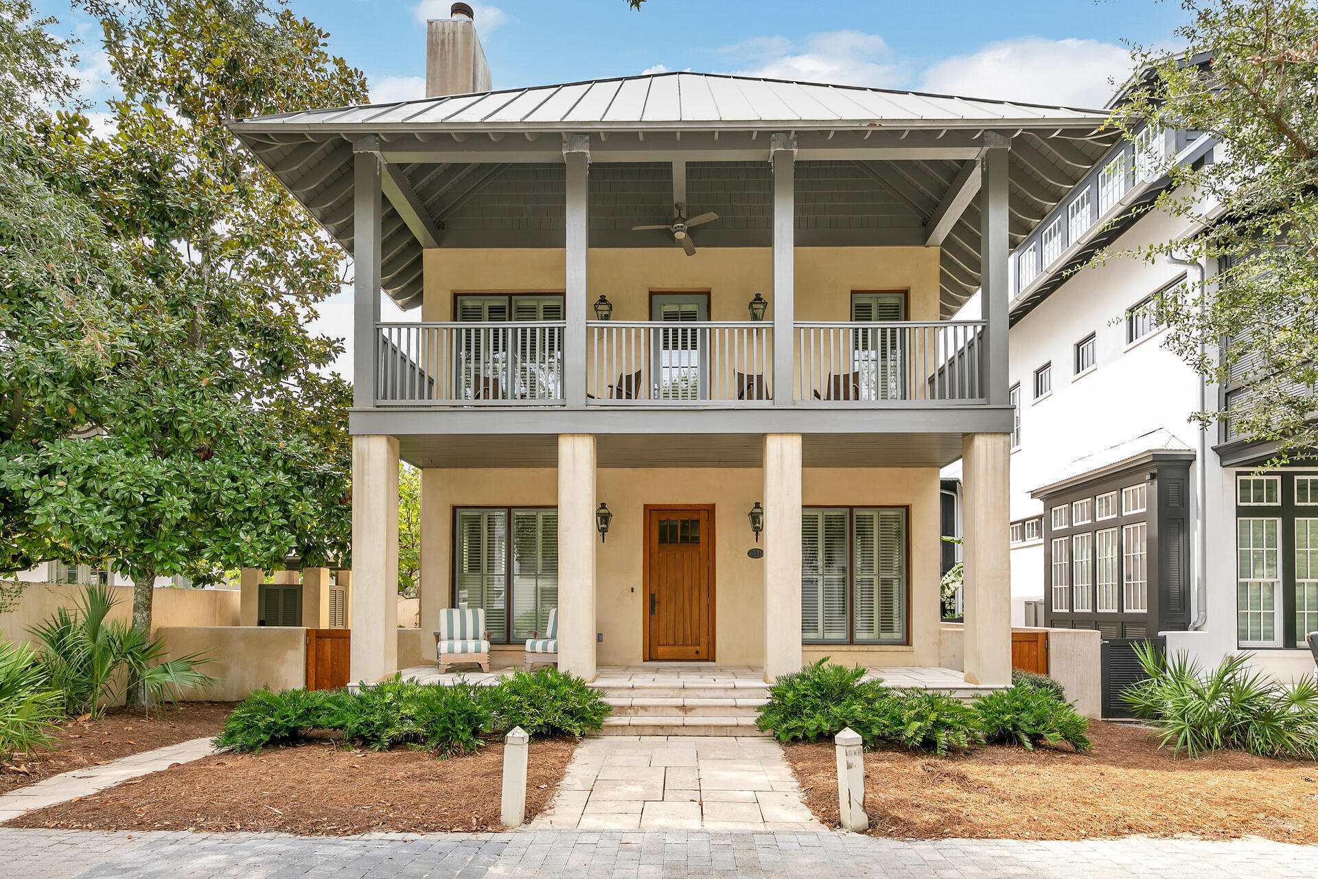 This stunning West Indies inspired home in Rosemary Beach has been completely transformed from its original roots.  A carriage house was added in 2012, along with a stunning courtyard with wood burning fireplace.  Light and bright, the first floor living space of the main home retained the original shiplap walls but added a beautiful coquina inspired fireplace surround.  A gorgeous kitchen opens to the living and dining area with cabinets to the ceiling and white quartz counters.  The jewel of the first floor is the large, glassed in sunroom with views of the courtyard fireplace.  Upstairs you will find an oversized primary bedroom with an updated bath, containing both a freestanding tub and a shower.  Two other guest rooms round out the second floor.  Possible room for expansion exists