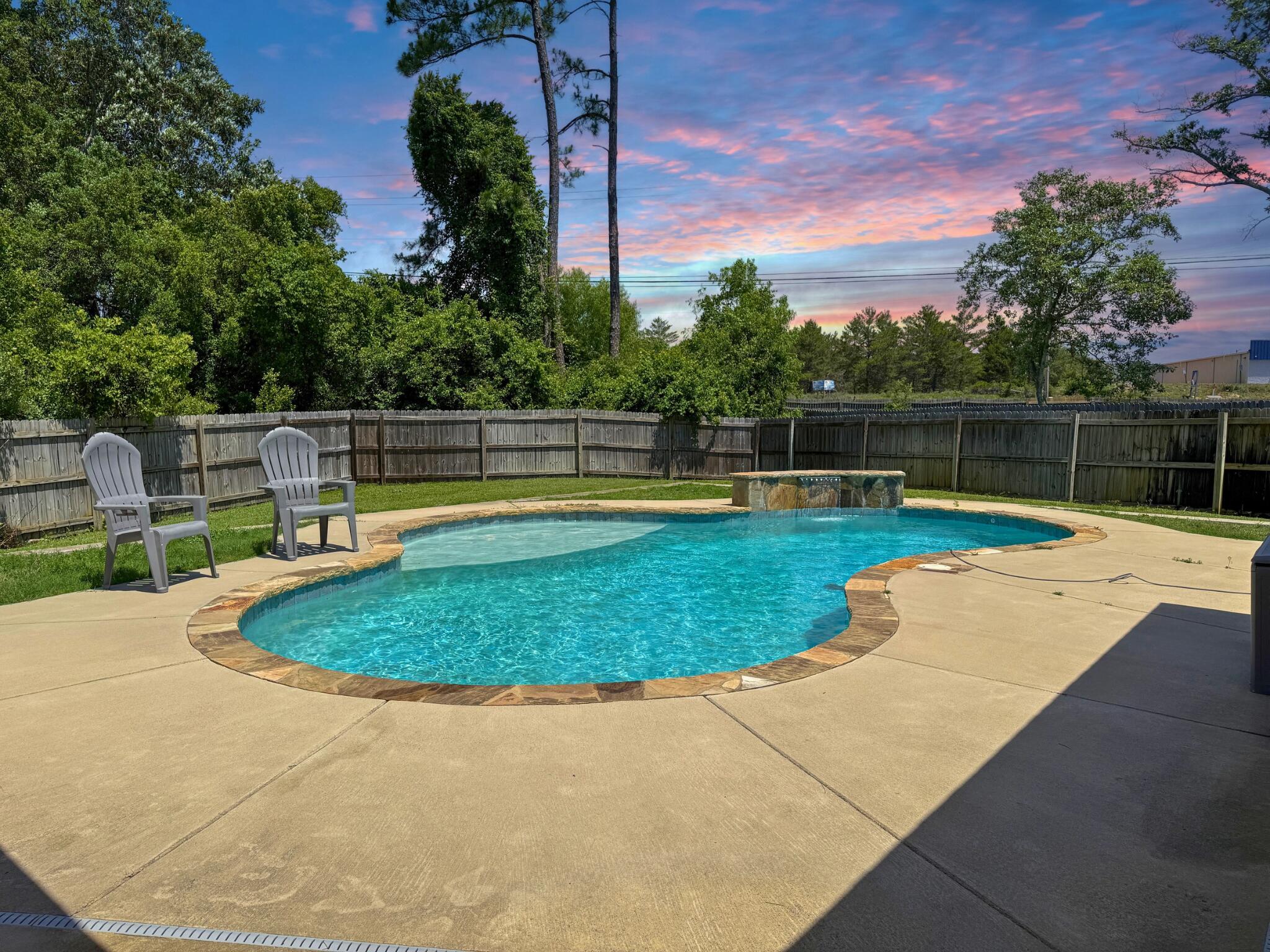 This updated 4-bedroom, 3-bath pool home with a private office and deeded access to the Santa Rosa Sound checks all the boxes. Inside, you'll find an open layout with vaulted ceilings, a shiplap accent wall, and a chef-worthy kitchen featuring granite counters, stainless appliances, a Samsung Bespoke fridge, center island, walk-in pantry, and a new Whirlpool microwave. The primary suite is tucked away and offers dual granite vanities, a soaking tub, tiled shower, water closet, and two walk-in closets. Three additional bedrooms are located on the opposite side of the home with two more full baths, all with LVP flooring and granite countertops. The private backyard is built for Florida living with a gunite pool that includes an ozone purification system, tanning ledge, waterfall, and LED color-changing lights. Footers are already in place if you want to add a screen enclosure. Other upgrades include interior paint (2023), Nest thermostat, Ring doorbell (2024), pool pump (2024), Whirlpool dishwasher (2021), and a sprinkler system on a well. There's no HOA, plenty of parking with an extended driveway and 2-car garage, and you're minutes from top-rated schools, Navarre Beach, Hurlburt Field, and local dining and shopping.