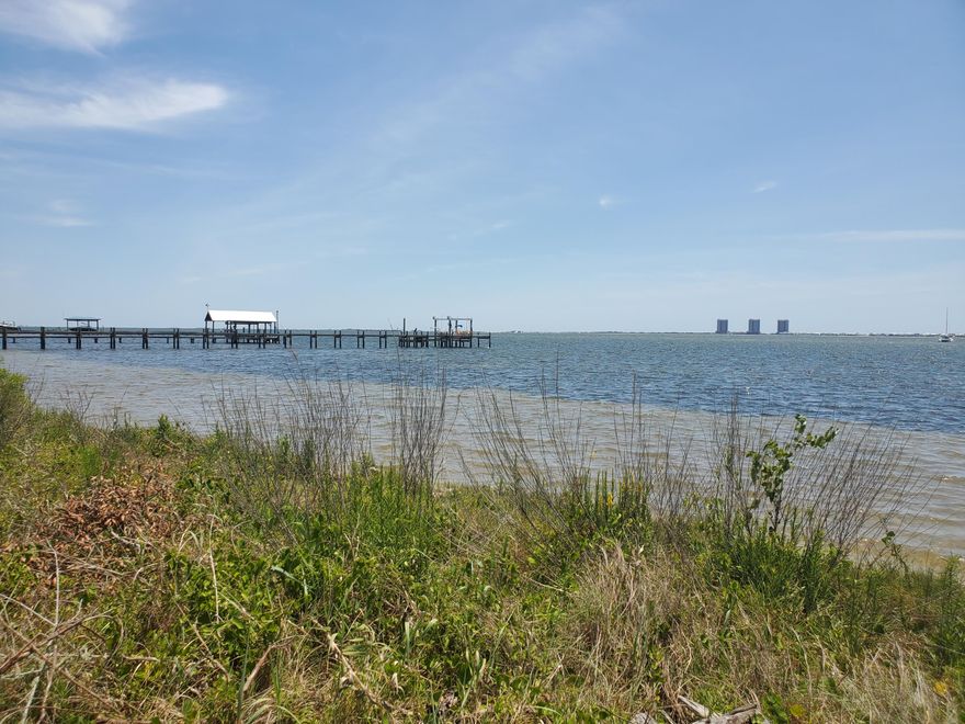 Own on this coveted street of large lots and panoramic waterfront views of Santa Rosa Sound and Santa Rosa Island at the horizon. Boating is ideal here, being just minutes to the hidden coves, restaurants, and Fort Pickens of the island. Fishing is terrific with the underwater grass beds nearby and the Gulf of Mexico pass only 15 - 20 minutes away. This beautiful vacant lot has so much to offer in a desirable area. Several beautiful trees are on the this very large 1 acre (.94 acre) lot. The property is right down the road from the Oriole Beach Boat Ramp and is just a short drive away from Gulf Breeze proper, Pensacola Beach and downtown Pensacola. In this waterfront community, people build their dream homes