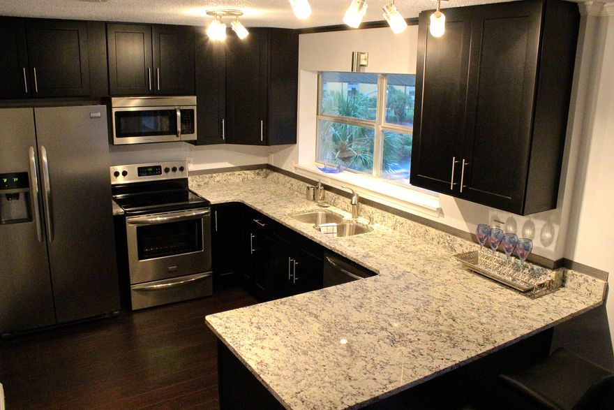 Gulf Views from this completely remodeled, move in ready 1BR/1BA condo on Okaloosa Island. No detail was overlooked in the renovation - crown molding, dark laminate flooring, granite counter tops, fresh paint & serene color scheme to name a few. Enjoy views of the Gulf of Mexico out your kitchen window in this modern kitchen with granite countertops, huge breakfast bar, custom, ceiling height, espresso stained cabinetry and stainless appliances. The bathroom features ceramic plank tile flooring and custom mosaic tile in shower. Washer and Dryer hookups. Tons of attic storage space with pull down staircase. Views of Brooks Bridge from front porch. New HVAC, everything is new! Excellent location with public beach access almost directly across from unit. Easy walk to beach.