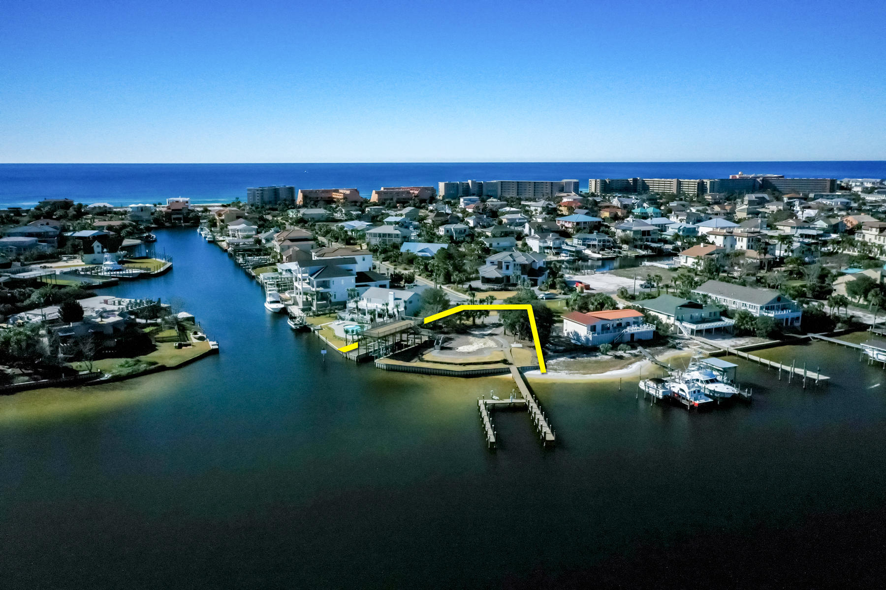 One of the most remarkable deep-water lots in all of Destin, Florida, which is beautifully oriented on the exclusive address of Holiday Isle and surrounded by 160'+ of the scenic harbor.  This lot offers a nearly pad-site ready opportunity to custom design and build your coastal retreat.  The elevation of the site is superb, and the vinyl sheet-pile bulkhead and terracing that are already in place will save the buyer considerable site costs.  A few stairs down from one of the piers give access to your private beach.  The property consists of two existing docks, which is incredibly rare, one of which will accommodate three lengthy vessels, and the other single-slip dock offers overhead cover, which cover also functions also as an expansive 18' x 50' sun deck.  Please..