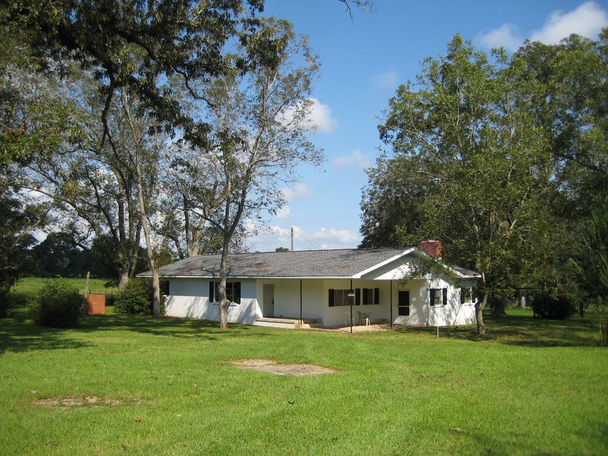 Welcome to your country home on 56 acres!!! Sturdy, concrete block home with a new roof and featuring 3 bedrooms and 2 baths. Great, original hardwood floors throughout the main home, with the exception of the kitchen. Eat-in-kitchen is open to the formal living room. Large informal family room is also located off of the kitchen as well as one bedroom and bath. Large utility and storage room off the back of the home. Parcel is just over 56 acres, mostly pasture and is fenced and cross-fenced. Great pecan trees and a fair amount of mature timber around the small stream. Property also features an older barn and chicken house. Beautiful rolling property, very fertile and already set up for cattle or horses. Make an appointment to see this beauty with lots of Hwy 85 frontage!
