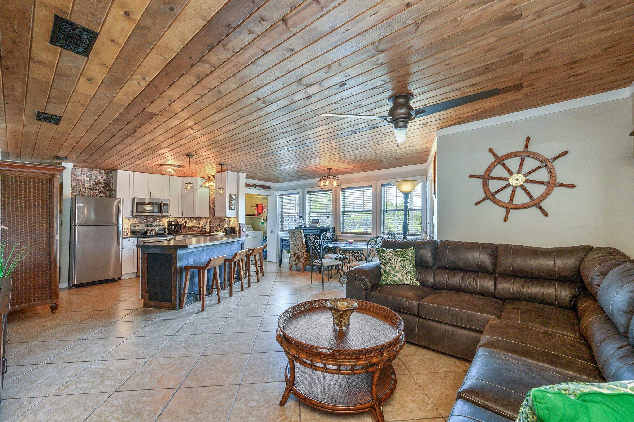 SELLER WILLING TO HELP WITH INTEREST RATE BUY DOWN! Welcome to your fully remodeled 2 bedroom, 2 bath second floor lakefront condo with stunning views! One of the first things you'll notice are the spectacular paneled ceilings throughout the condo, lending to the lakefront vibe. The open floor plan makes the living and dining area feel spacious with plenty of room for all your guests, whether cooking, eating, or relaxing together. The kitchen boasts granite countertops and stainless steel appliances, and the counter to ceiling tiled backsplash makes clean up a breeze! The round table is great for easy conversation over a meal, and the counter height bar top ensures that you have plenty of seats for everyone.