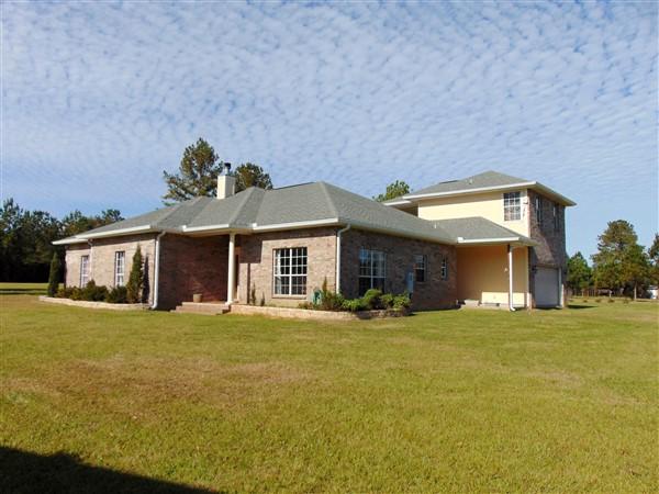 This amazing home & apx 14.5 acres (3 parcels) backs up to 210,000+ acres of Blackwater River State Forest & Park (endless trails, lakes, rivers, creeks, hunting, fishing hiking...)! The custom brick home is a dream with 3 BR, 2.5 baths & addtl 1 BR, 1 ba studio over garage. Home features 10' ceilings, recessed lighting, fireplace, covered porch & patio, large laundry. Master BR is 16x16; Master bath has double vanities, Jacuzzi, walk-in shower, massive walk-in closet also 10' tall (you won't believe the storage). Ext features include pole barn; apx 5 ac fenced pasture w/ solar powered electric fence; barn/stables; Chicken coop; Turkey pens; Greenhouse; Numerous fruit trees, Garden area; herb gardens & so much more! Home is 2749 SF with over 4,000 under roof! This is a definite must see!