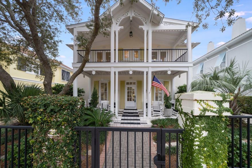 Under contract with 72 hour kick-out clause - Discover this meticulously maintained and furnished Caribbean-inspired residence nestled within the secure confines of the Caribe gated neighborhood. Upon arrival, a sprawling front porch extends a warm welcome, setting the tone for the inviting atmosphere within. Step inside to experience an open design where the living area boasts a gas fireplace, and the well-appointed kitchen showcases stainless steel appliances, a gas stove, and a convenient trash compactor.The first floor reveals additional amenities, including a powder room and the primary bedroom, granting access to a charming side deck adorned with a pergola. The primary bath exudes luxury with double sinks and a tiled shower.