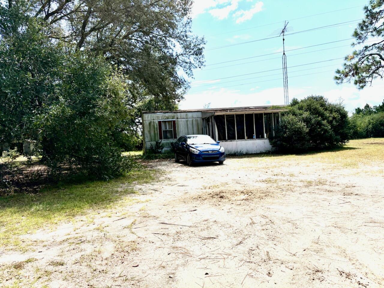 Beautiful 1 acre with well and septic tank, with a 24x24' garage (needs work) and a 1977 single wide add-on room with a total 960 sf (needs work) with many possibilities. 2 other yard buildings, one with washer hook-ups. This could also be a beautiful home site. Several options for the use of this nice lot and its amenities. Shown by appointment only. Property being sold ''AS IS.'' CASH ONLY SALES CONTRACTS,