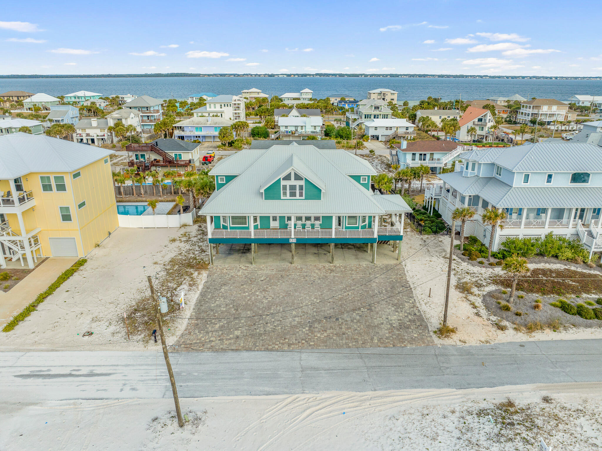 Welcome to this breathtaking 7-bedroom, 8.5-bathroom coastal oasis, offering 4,624 sq. ft. of elegant living space and Gulf-front views. Situated on a large gulf view lot, this home is the perfect blend of elegance and comfort, with thoughtful upgrades throughout and multiple areas to unwind and entertain. Enjoy the gulf breeze from one of the home's large decks, both front and back, designed for outdoor living and stunning water views. With over $277,000 on the books for 2025 rental income. Welcome to this breathtaking 7-bedroom, 8.5-bathroom coastal oasis, offering 4,624 sq. ft. of elegant living space and Gulf-front views. Situated on a large gulf view lot, this home is the perfect blend of elegance and comfort, with thoughtful upgrades throughout and multiple areas to unwind and entertain. Enjoy the gulf breeze from one of the home's large decks, both front and back, designed for outdoor living and stunning water views. Off the balcony is a spacious, open-concept design which features a generous living space flowing into a large expansive kitchen, ideal for both daily living and hosting guests. The kitchen boasts sleek quartz countertops, updated cabinets, and plenty of seating space. On the main level there are four large bedrooms, including the Gulf Front master. All feature en-suite bathrooms and large walk-in closets. There is a half bath located right off the back deck for ease of access from the pool area and a large laundry room with additional storage and fridge. Upstairs includes another large second living space and the remaining three bedrooms and four full baths featuring updated bathrooms and newly renovated spaces. Also included upstairs are three separate cozy cubby bedrooms that are ideal for guests or versatile use. With many additional features and upgrades including a new pool liner, new natural gas pool heater, new exterior HVAC units, new hot water heaters, metal roof, fully furnished, ext. The exterior of the property features an oversized carport and large paver driveway which can host up to 15 cars and host large events for additional use or income opportunities. Maximizing the use of space, this property is a top-tier vacation rental, consistently grossing over $225,000 annually, offering a lucrative investment opportunity. Rental revenue for 2025 is expected to be over $300,000 with currently $277,000 on the books. This rare gem is truly a one-of-a-kind opportunity  for both private living or as a profitable rental.