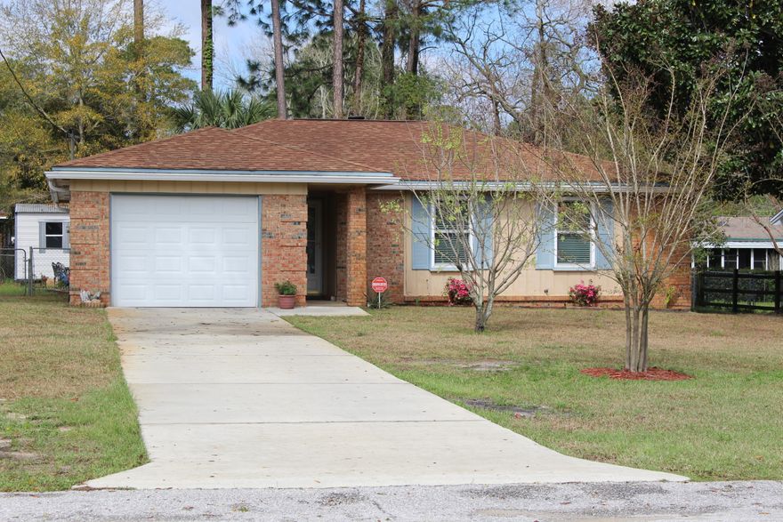 Heart of Niceville humble and quaint three bedroom two bath home awaits you. Don't allow the year built to fool you, there has been updates galore in this open floor plan featuring ceramic tile floors in the main living areas. Double pane windows and screens installed in 2011 with hurricane shutters add home protection along with extra savings on a home insurance policy. Roof replaced in 2005. Fresh paint using earth tones make this home open and bright. Recently updated kitchen boasts 42 inch cabinets and new counter-tops with a double ceramic sink. The breakfast bar opens to the living room with a lovely, corner fireplace that is the centerpiece of the room. The cozy dining area is just off the kitchen. French doors open to the covered back patio or enjoy the cool summer nights on the additional open patio. All interior doors are white, six panel style. Common size bedrooms with great closet space. Master bedroom with full bath settles into the back of the house. HVAC ductwork all replaced in 2009. Gutters surround the house. Beautiful trees and shrubs line the backyard. There is a yard building for your outdoor storage needs.  Sprinkler system installed in the front yard on lawn pump with timer for easy maintenance. Washer and dryer hook-ups are located in the one car garage. Termite bond in place.